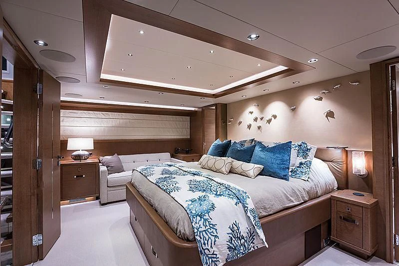 a bedroom with a bed and a couch aboard HAT TRICK Yacht for Sale