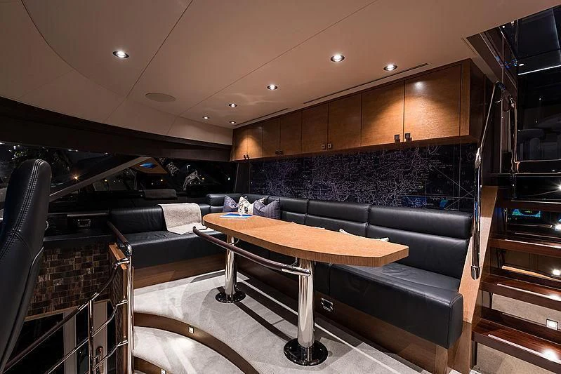 a room with a table and couches aboard HAT TRICK Yacht for Sale