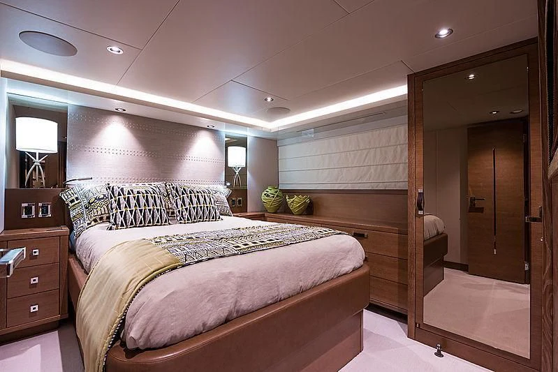 a bedroom with a bed and a mirror aboard HAT TRICK Yacht for Sale