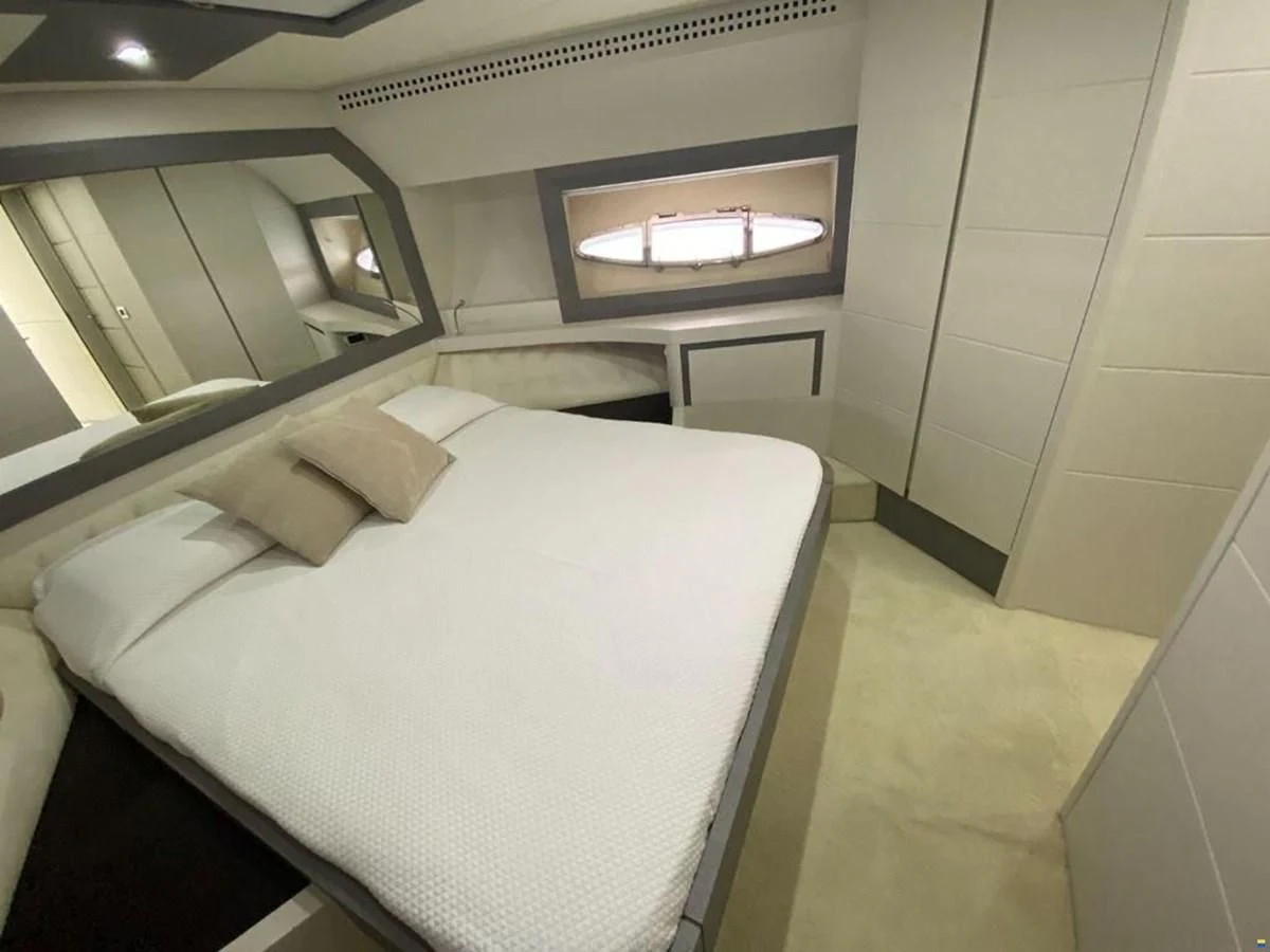 a room with a bed and a mirror aboard PERSHING 72 Yacht for Sale