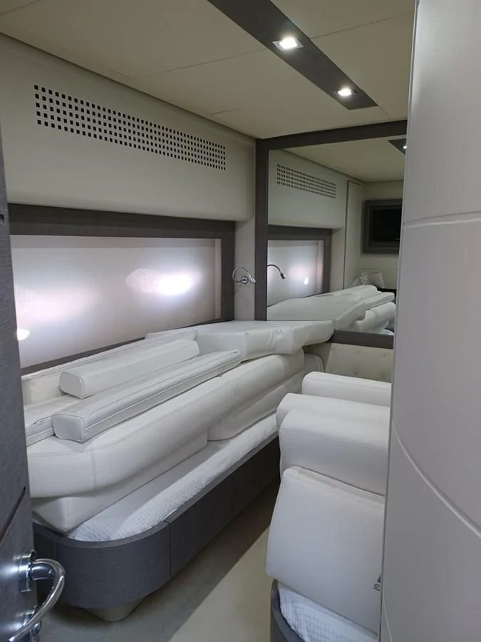 a room with a row of white beds aboard PERSHING 72 Yacht for Sale