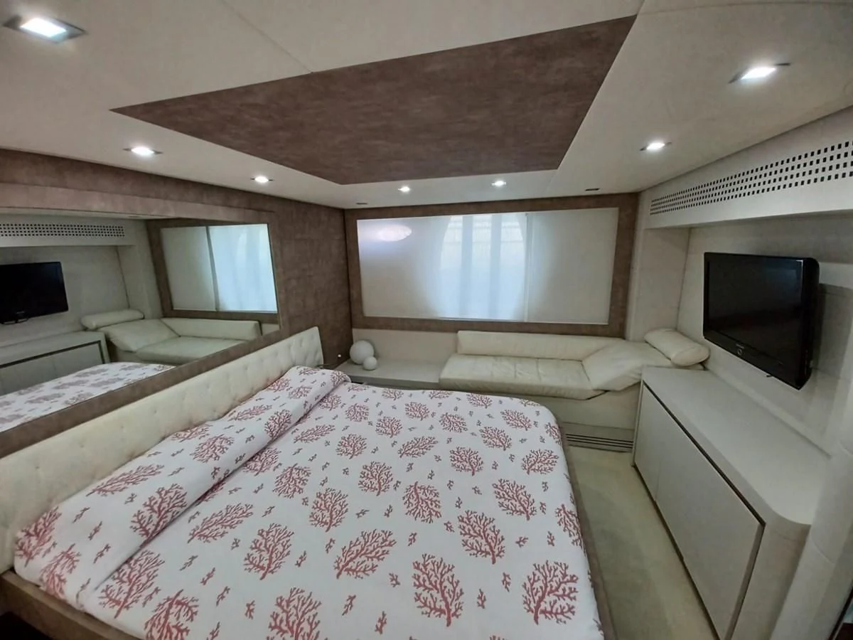 a bedroom with a bed and a television aboard PERSHING 72 Yacht for Sale
