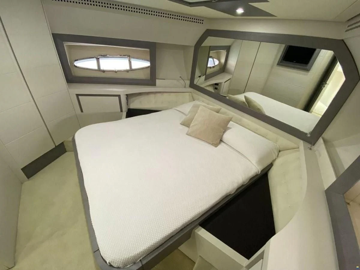a room with a bed and a mirror aboard PERSHING 72 Yacht for Sale