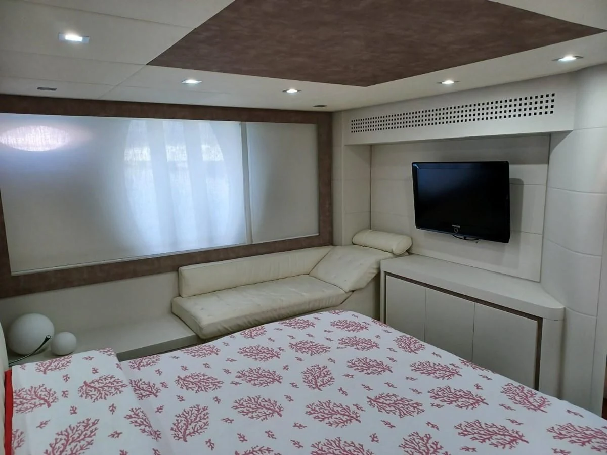 a bed with a television on the wall aboard PERSHING 72 Yacht for Sale
