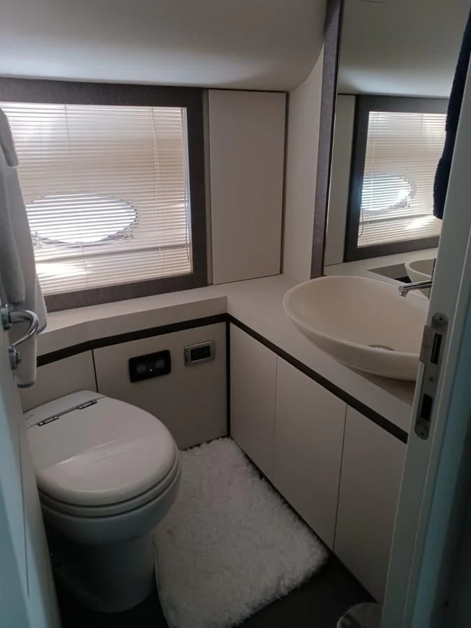 a small bathroom with a toilet and sink aboard PERSHING 72 Yacht for Sale