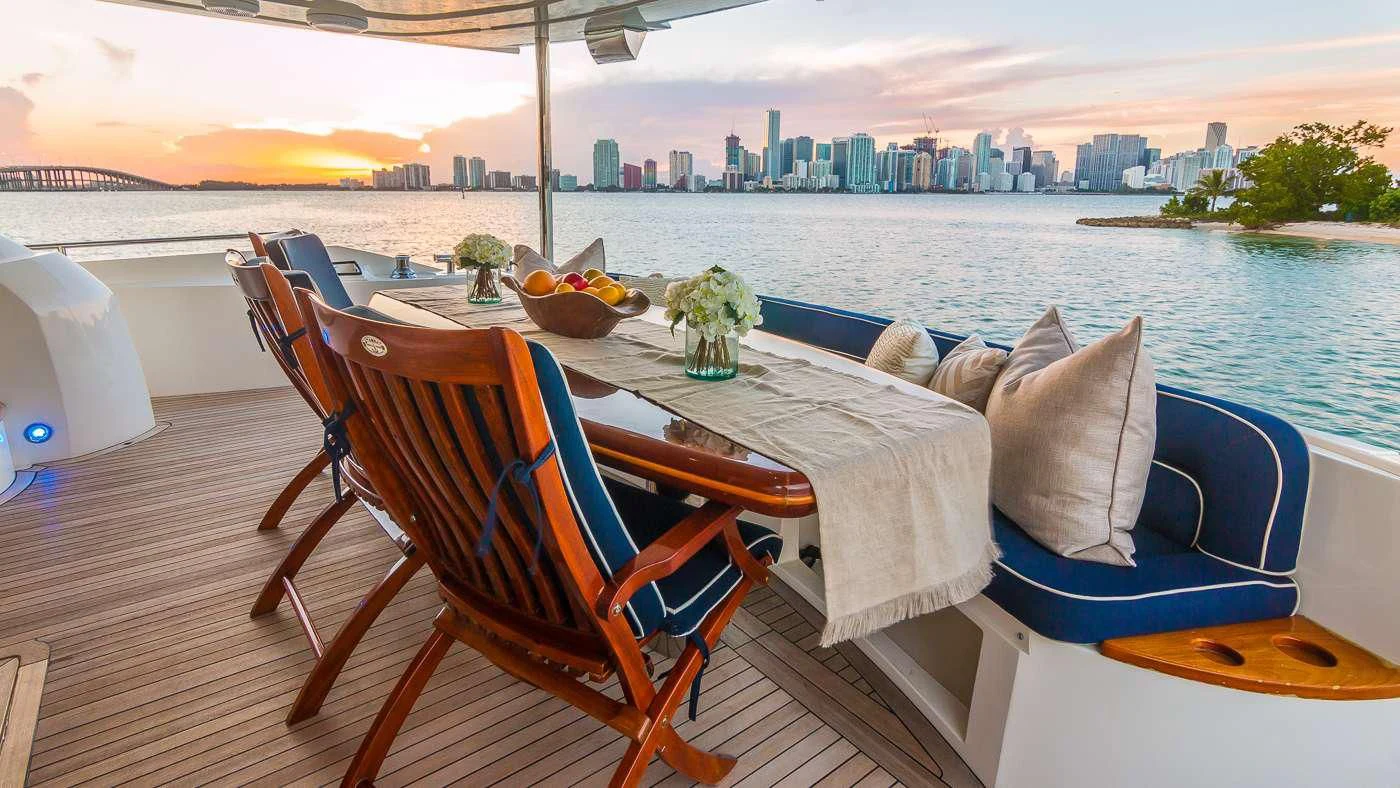 a table with chairs on it next to a body of water aboard SS ARTS Yacht for Sale
