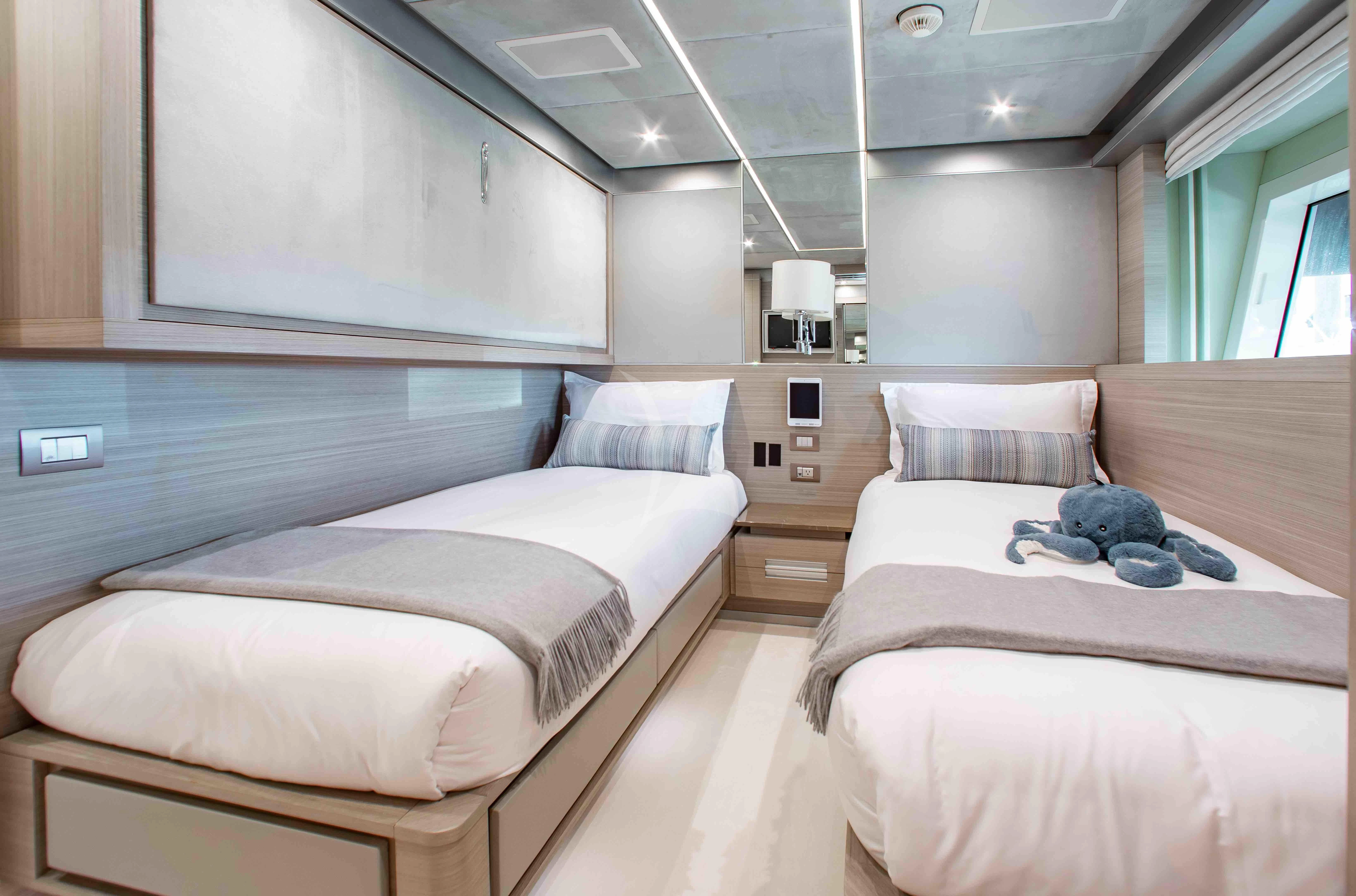 a room with beds and a window aboard EMINA Yacht for Charter