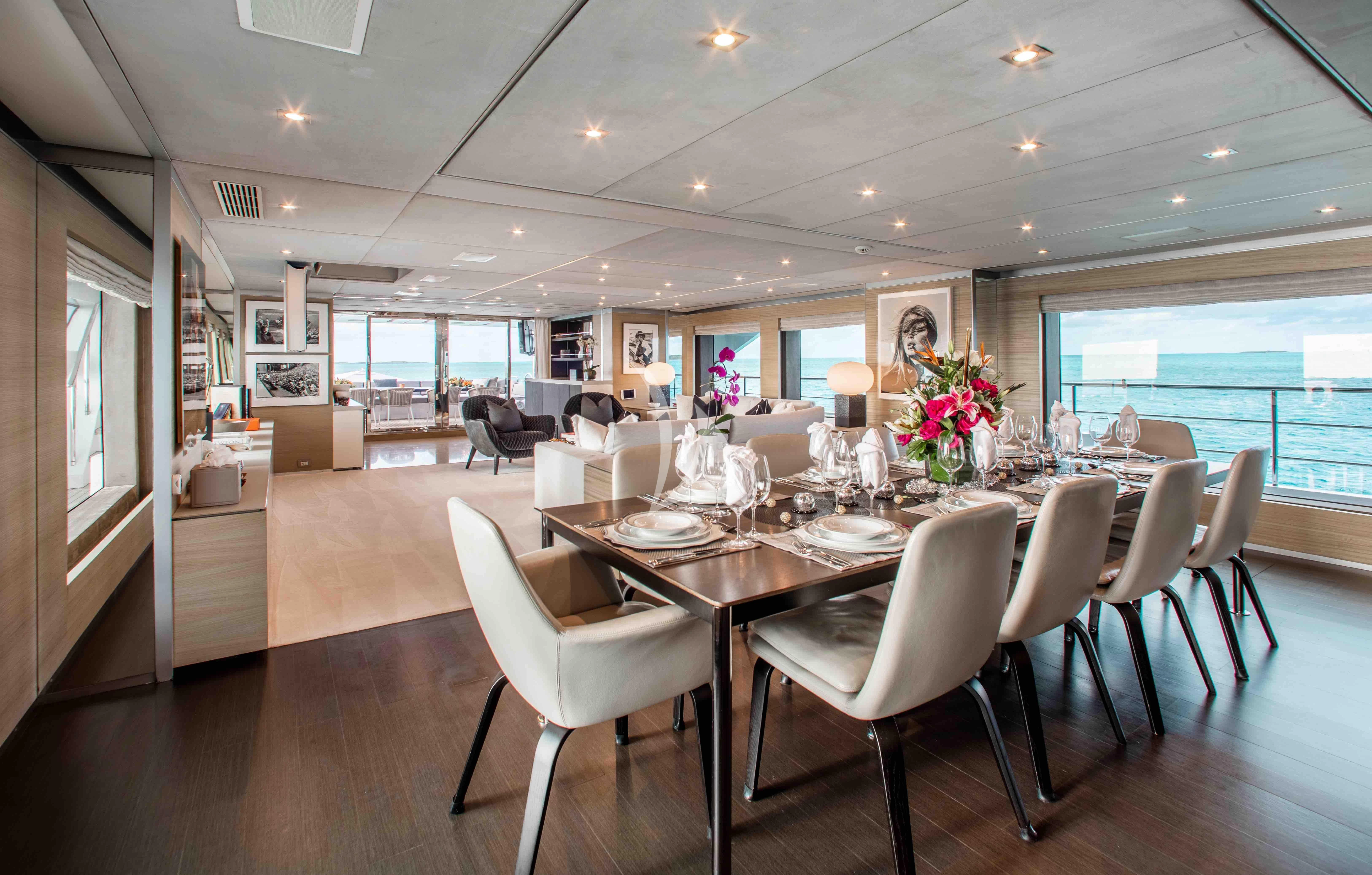 a large dining room with white chairs aboard EMINA Yacht for Charter