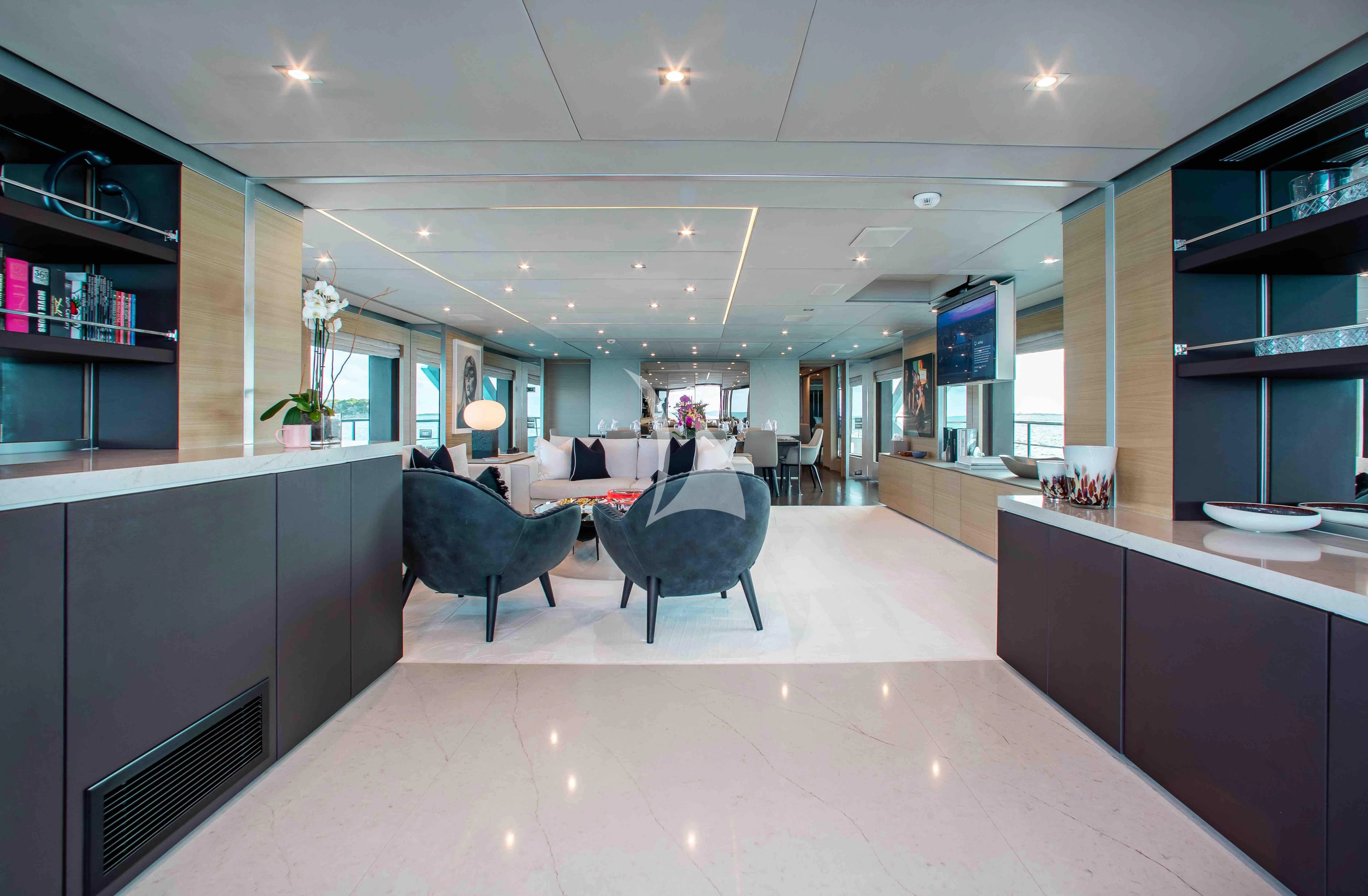 a room with a table chairs and a tv aboard EMINA Yacht for Charter