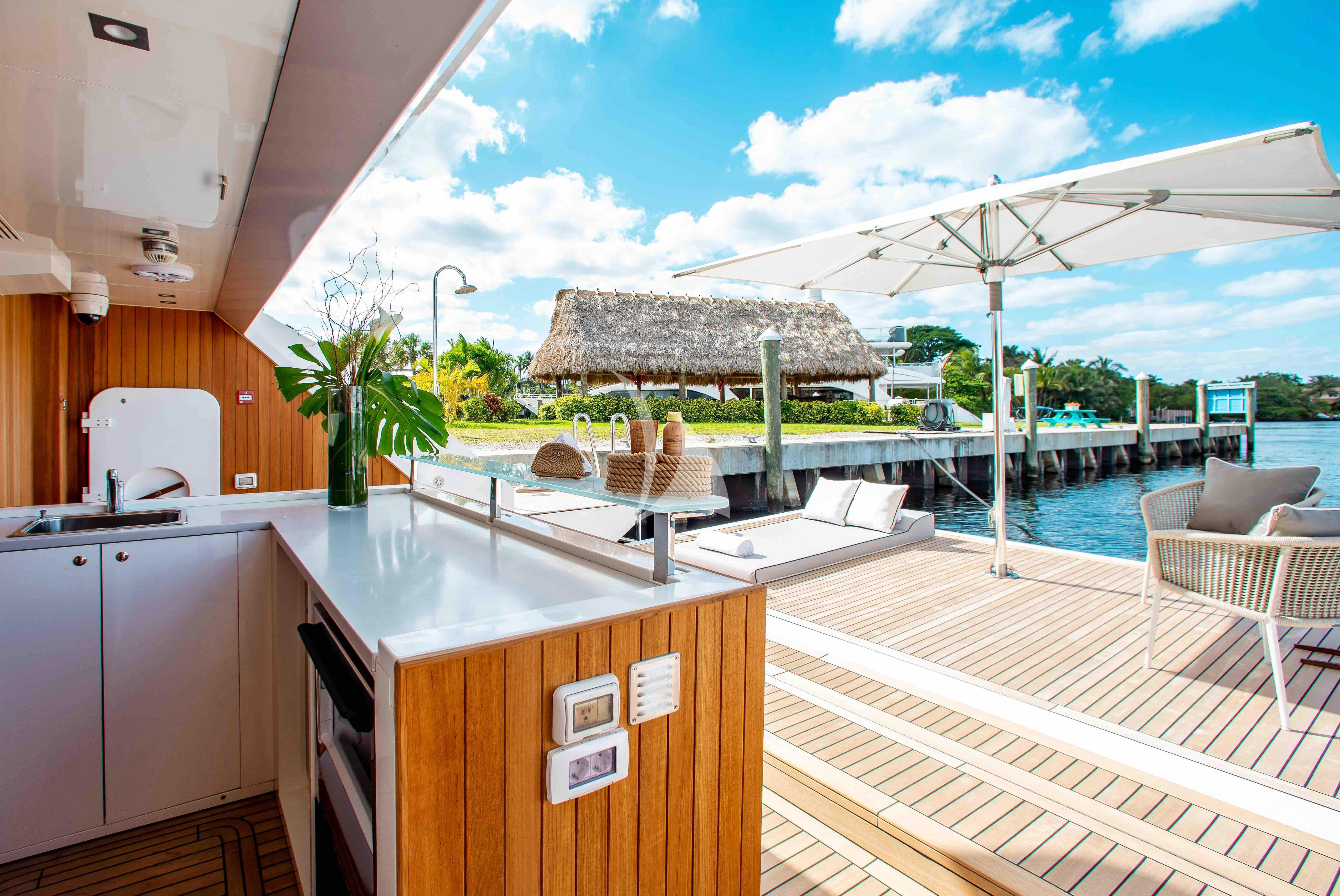 a large outdoor kitchen with a bar and pool aboard EMINA Yacht for Charter