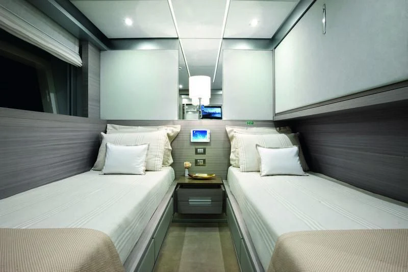 a room with beds and a window aboard EMINA Yacht for Charter