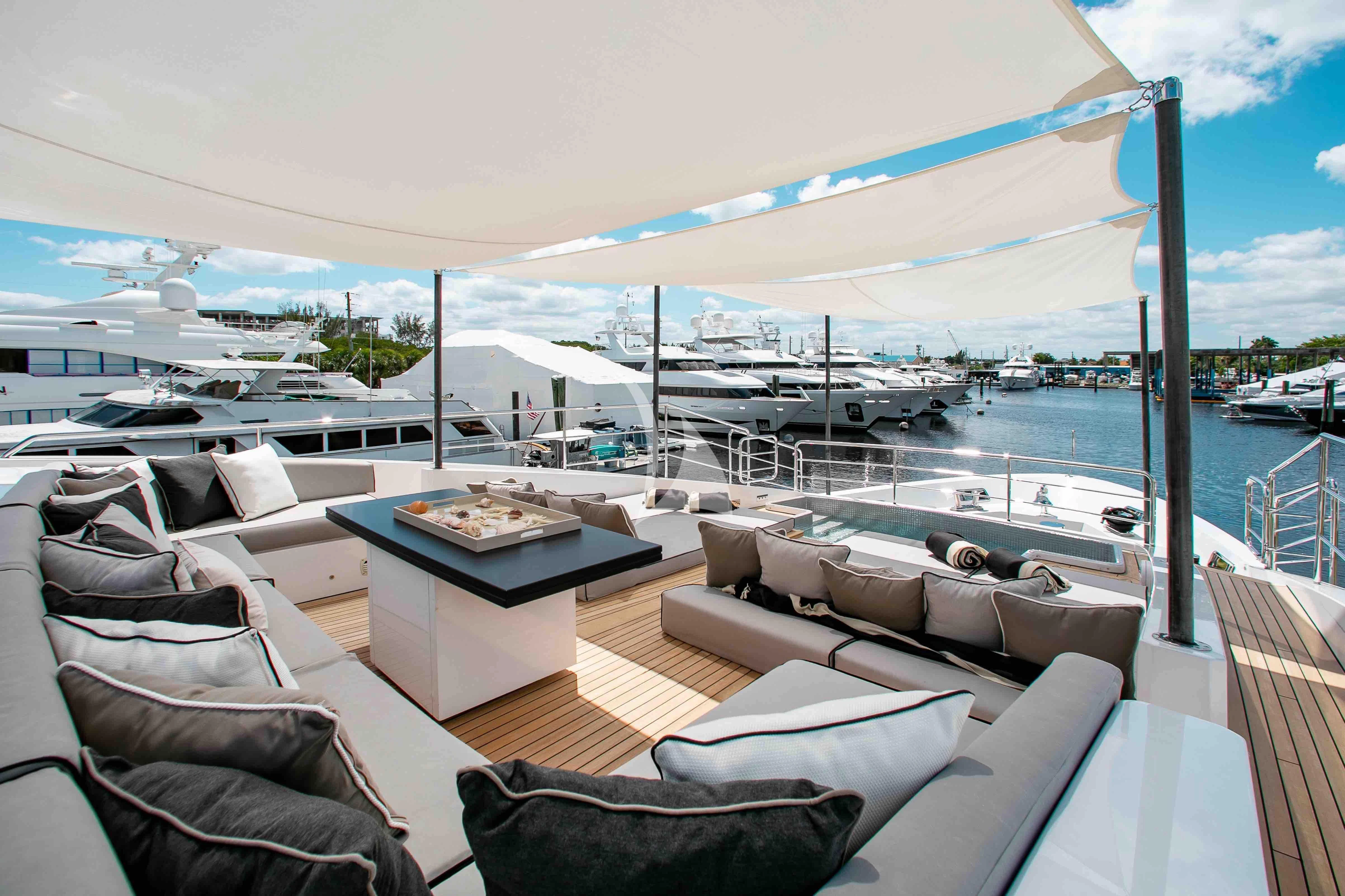 a deck with a table and chairs on it aboard EMINA Yacht for Charter