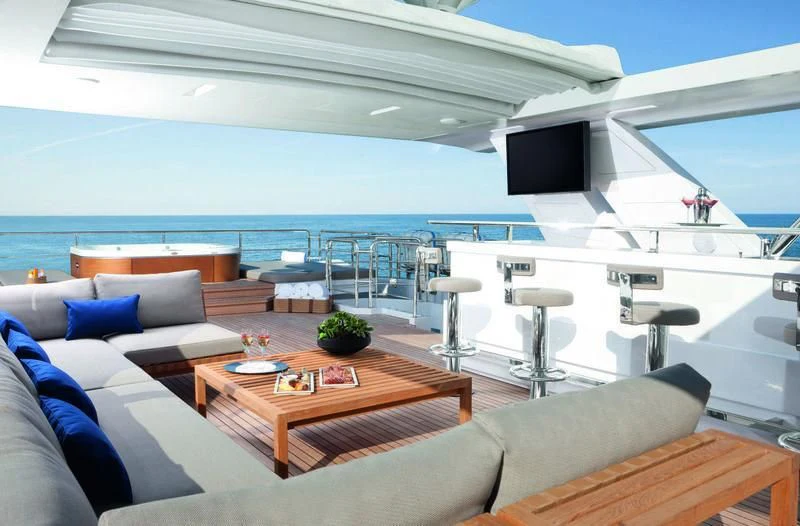 a large white boat with a table and chairs on a deck aboard EMINA Yacht for Charter