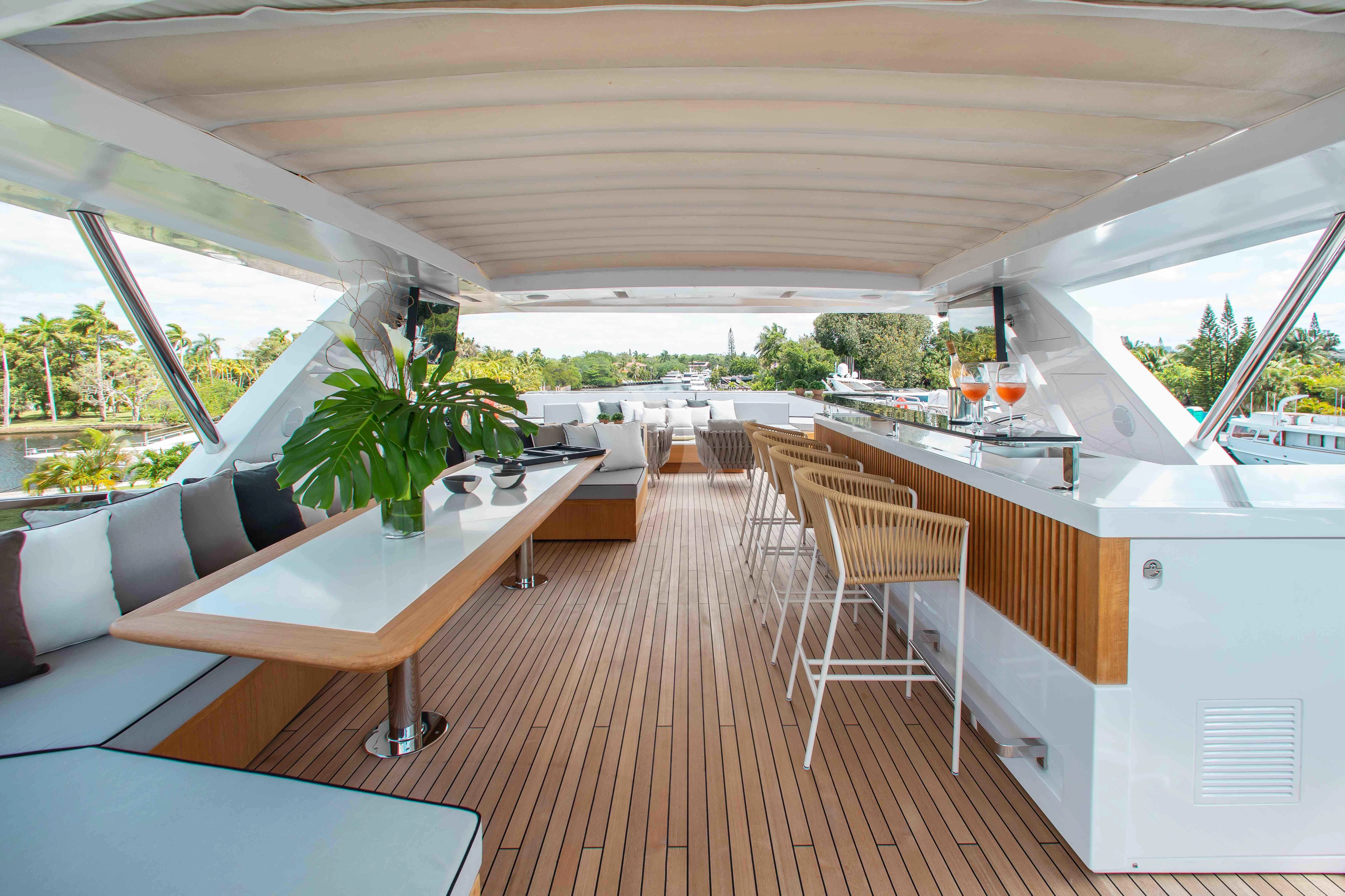a room with a table chairs and plants aboard EMINA Yacht for Charter