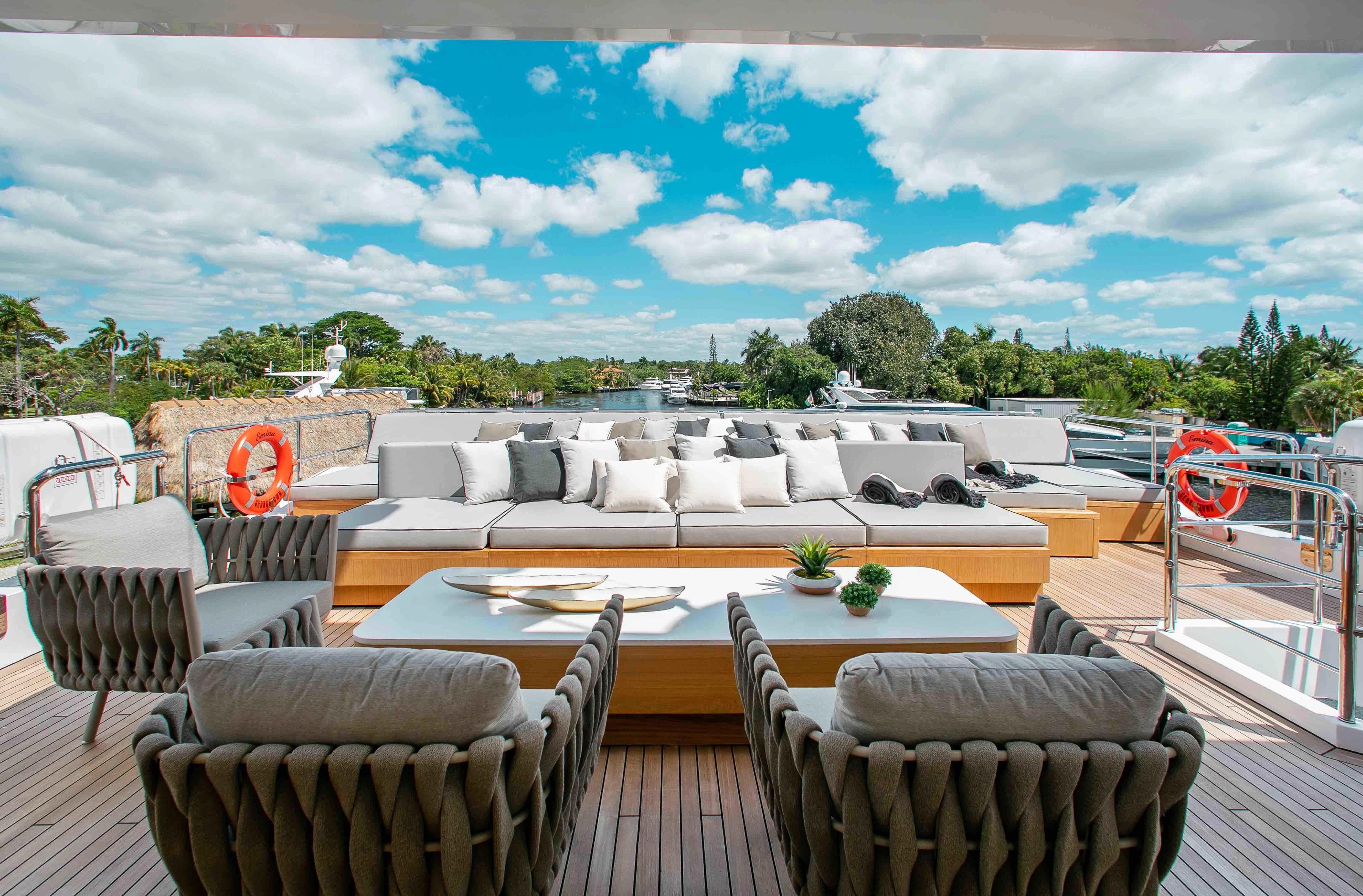 a large pool with a table and chairs on a deck aboard EMINA Yacht for Charter