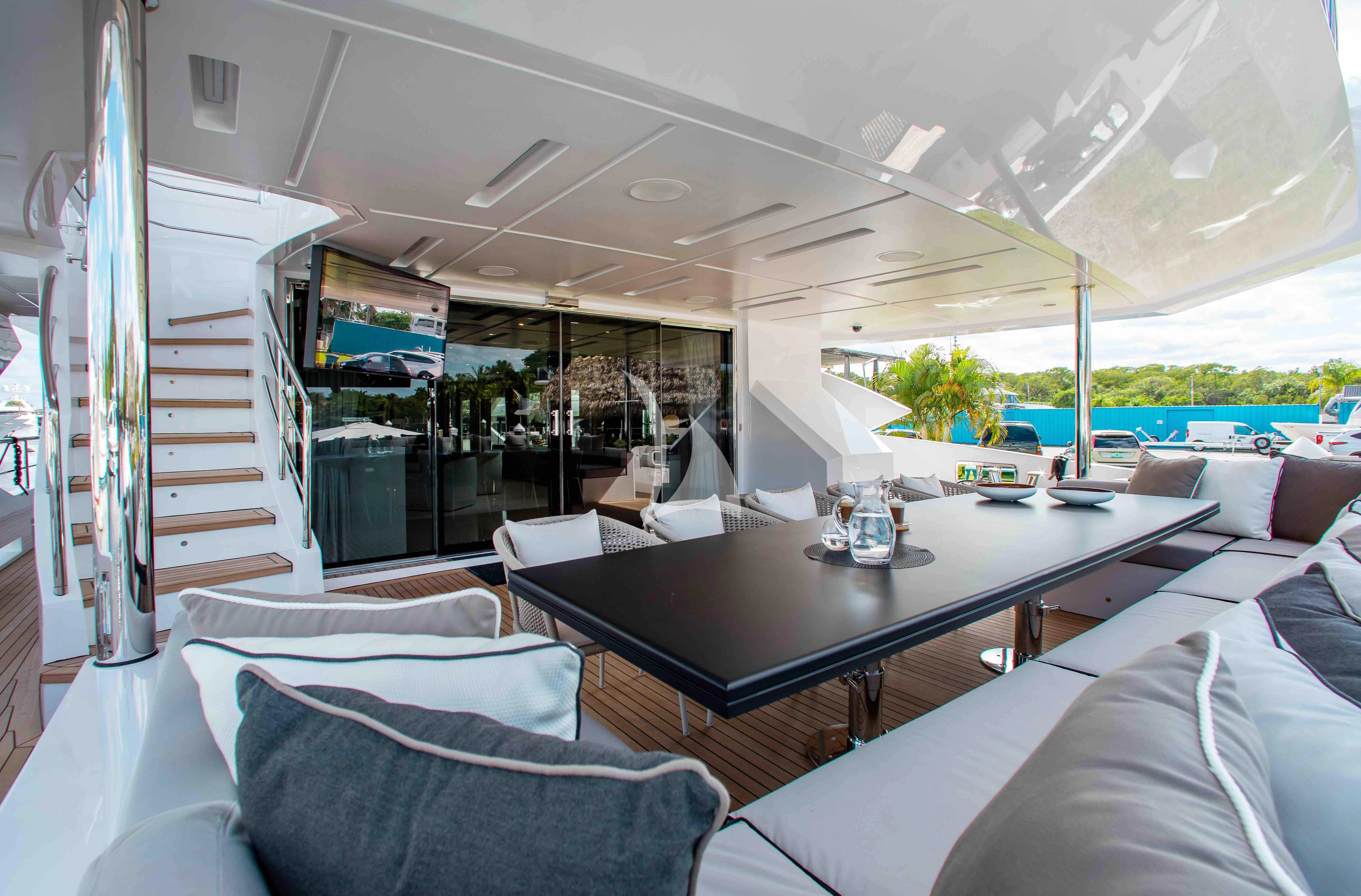 a living room with a large glass table and a large window aboard EMINA Yacht for Charter