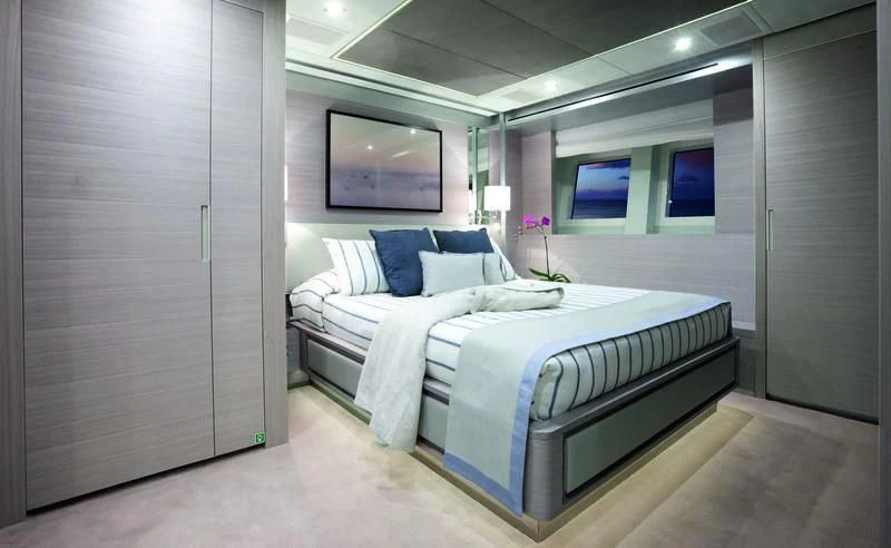 a room with a bed and a television aboard EMINA Yacht for Charter