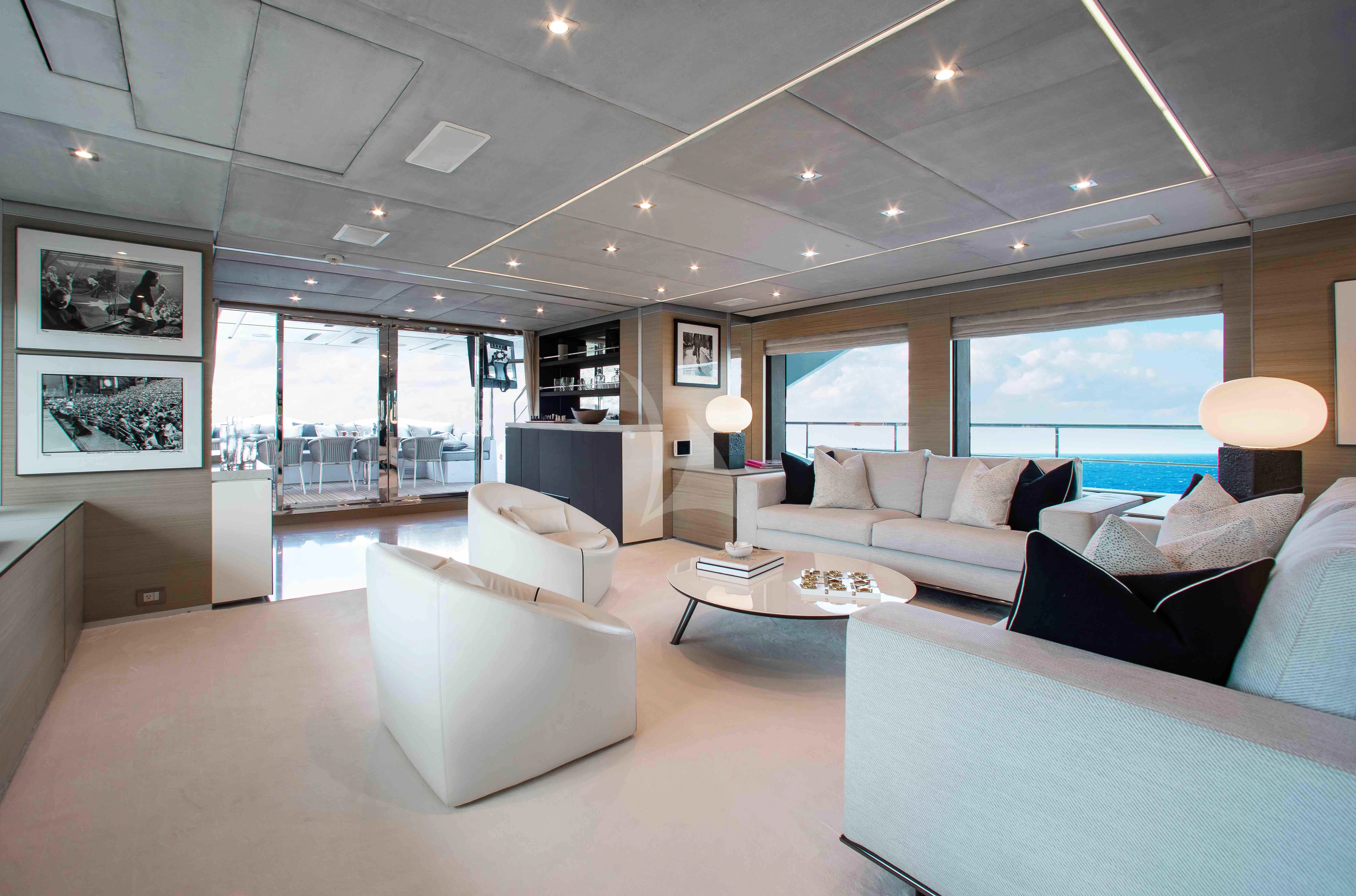 a large living room with white couches and a large window aboard EMINA Yacht for Charter