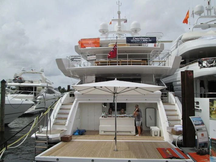 a large white ship with a group of people walking on a dock aboard EMINA Yacht for Charter