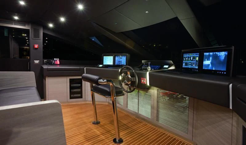 a room with a large television and a table with chairs and a computer aboard EMINA Yacht for Charter