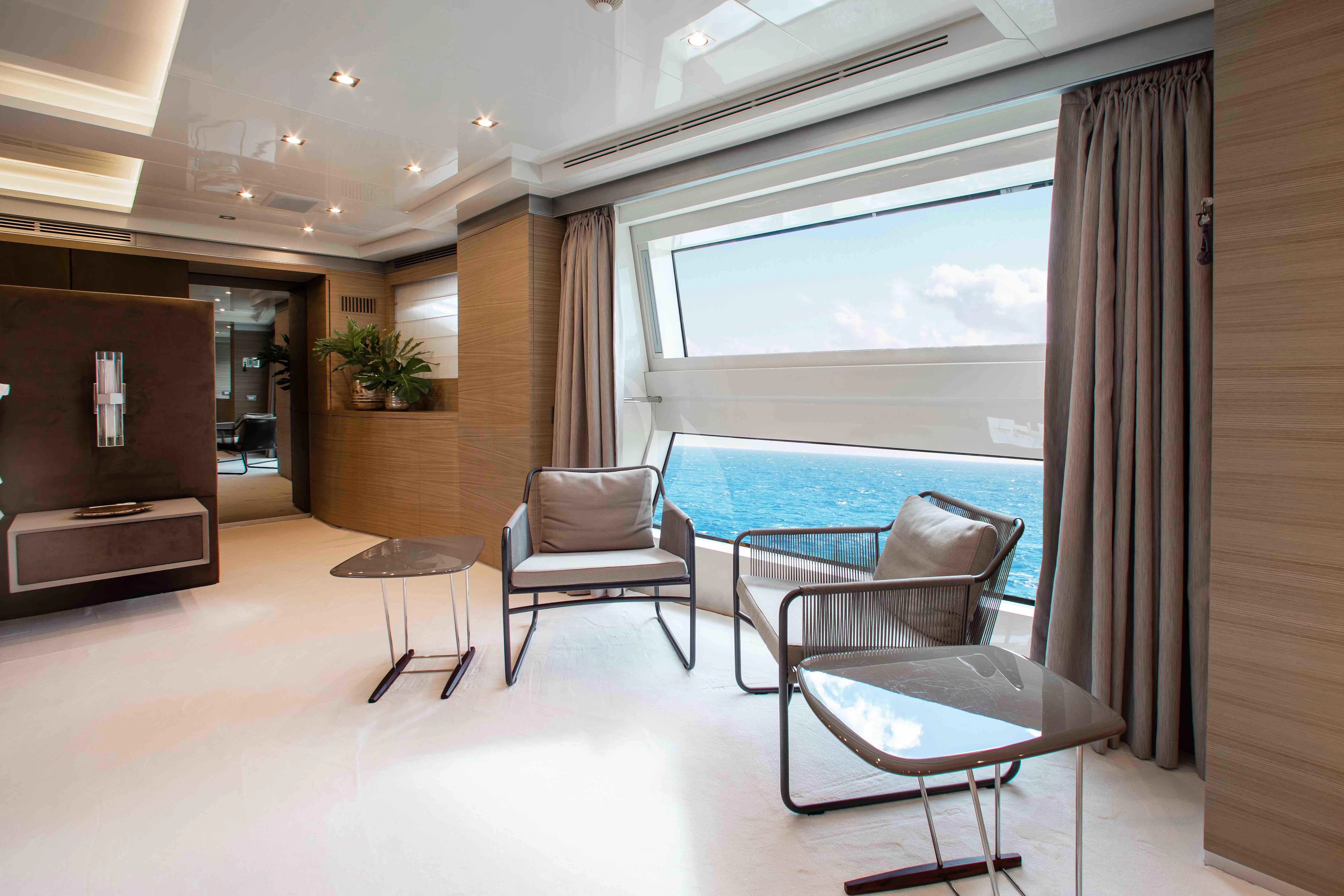 a room with a table chairs and a large blue pool aboard EMINA Yacht for Charter