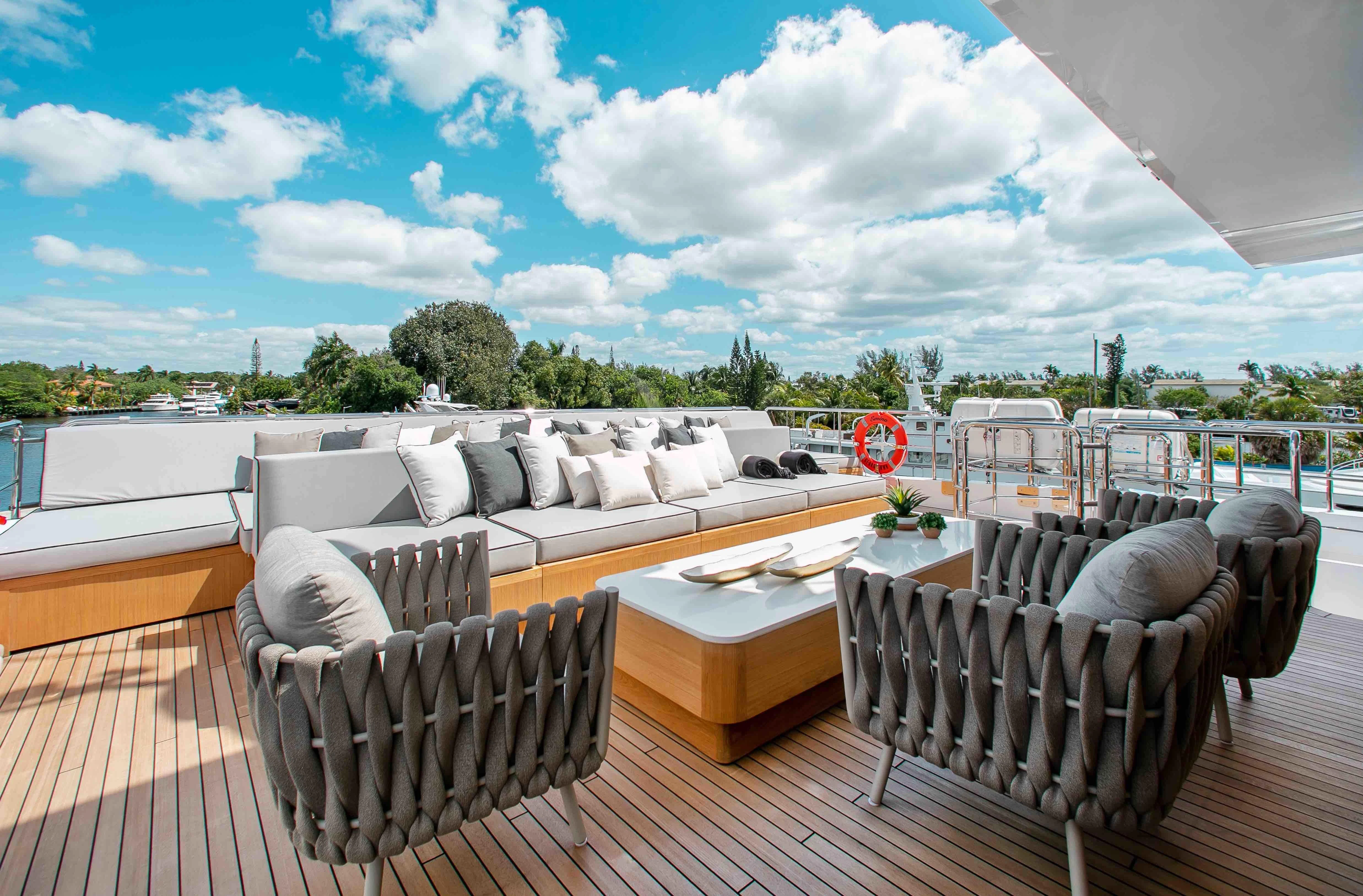 a deck with chairs and a table on it aboard EMINA Yacht for Charter
