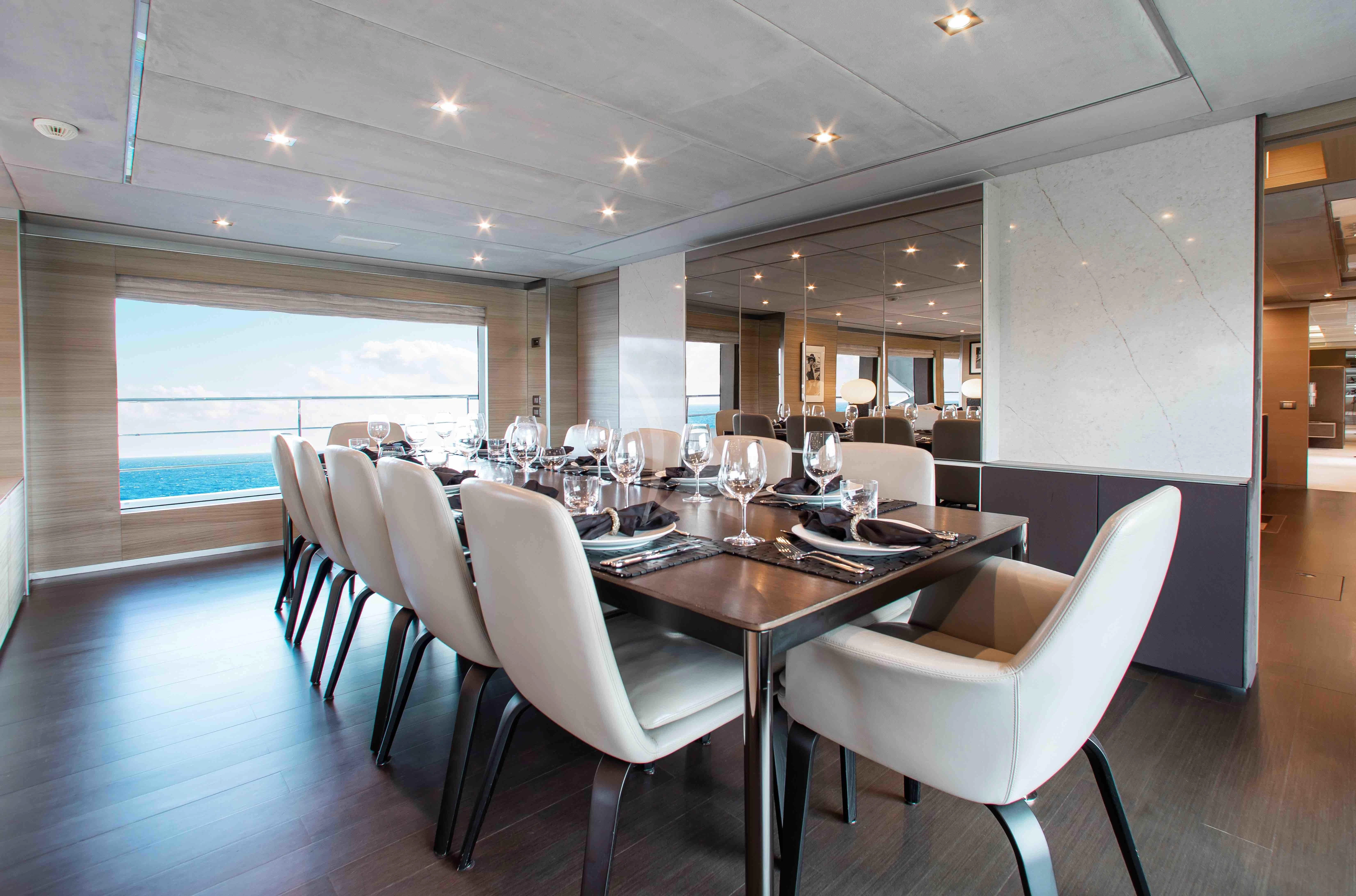 a large dining room with white chairs aboard EMINA Yacht for Charter