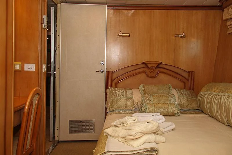 a bed with a white sheet and pillows on it aboard PRINCESS OF PALAU Yacht for Sale