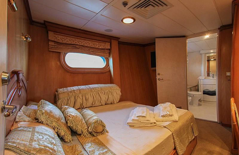 a bedroom with a bed and a mirror aboard PRINCESS OF PALAU Yacht for Sale