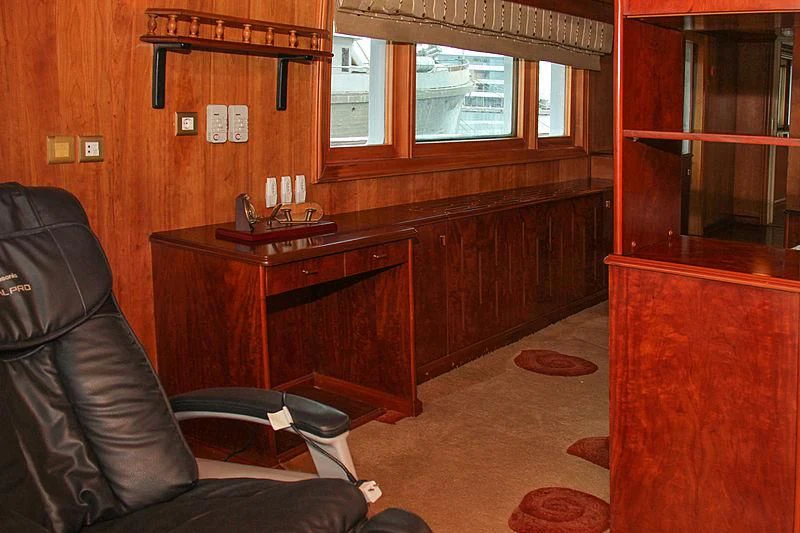 a living room with a leather chair and a desk aboard PRINCESS OF PALAU Yacht for Sale
