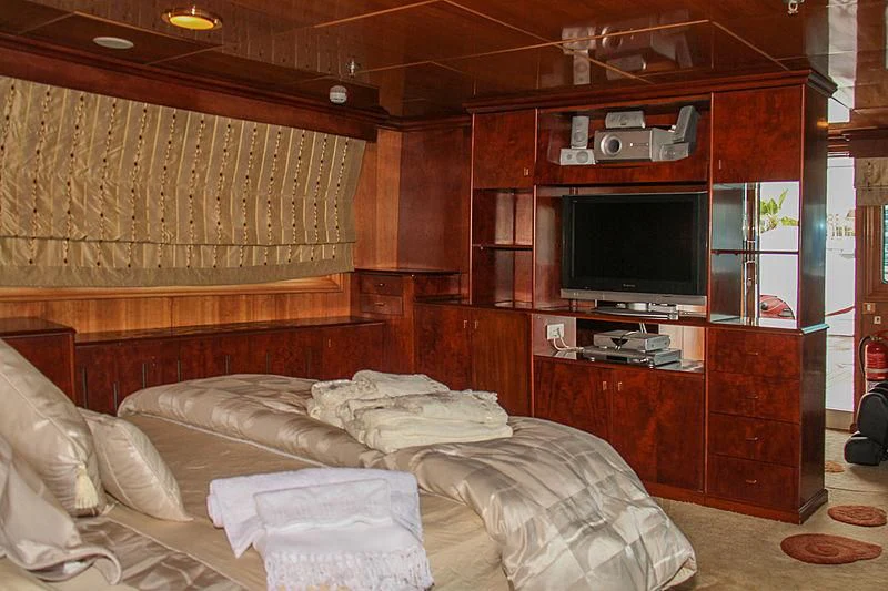 a room with a bed and a television aboard PRINCESS OF PALAU Yacht for Sale