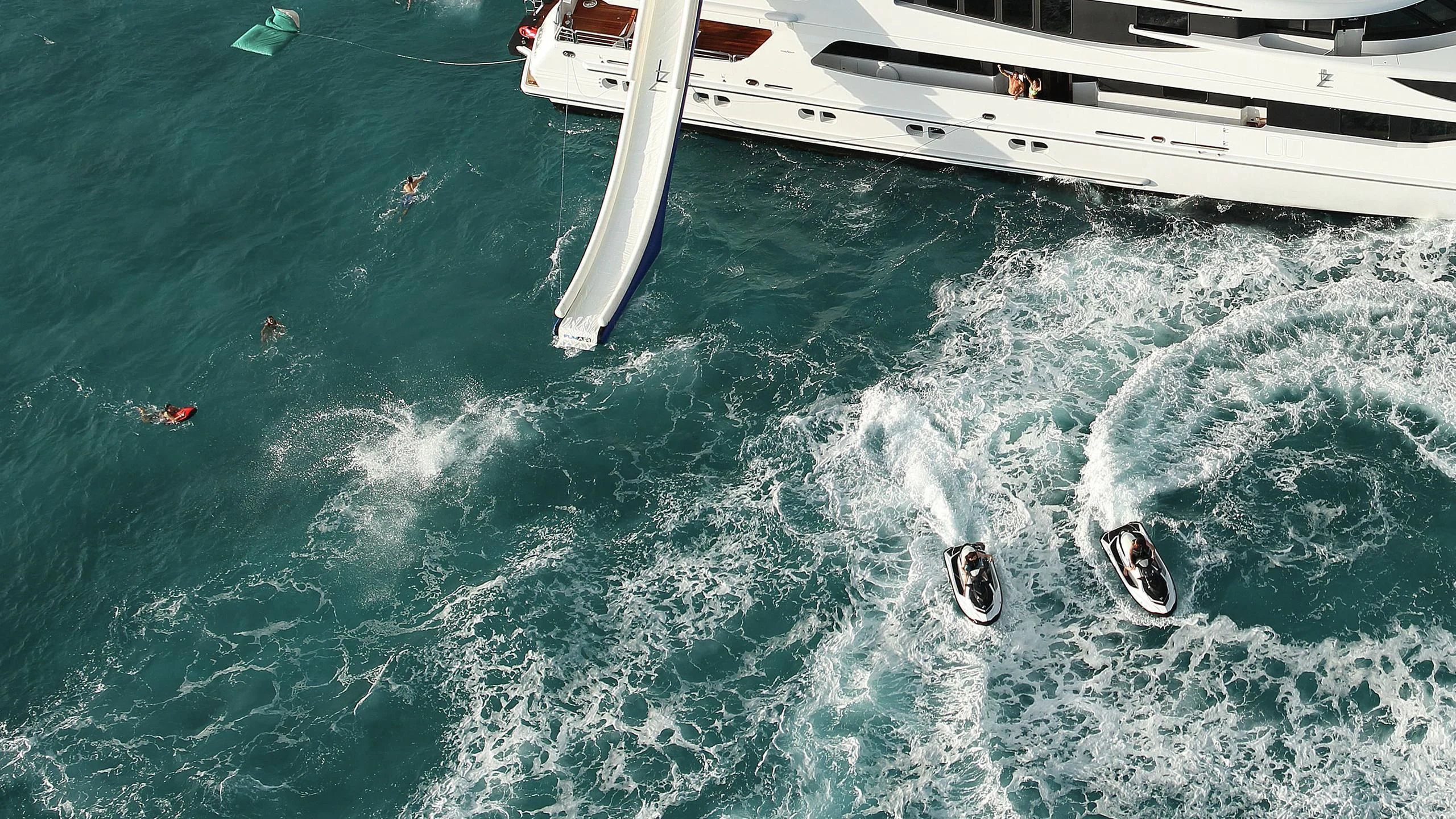 a group of people swimming in the water aboard AO Yacht for Sale