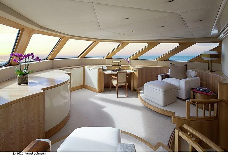 a room with tables chairs and a vase of flowers aboard AO Yacht for Sale