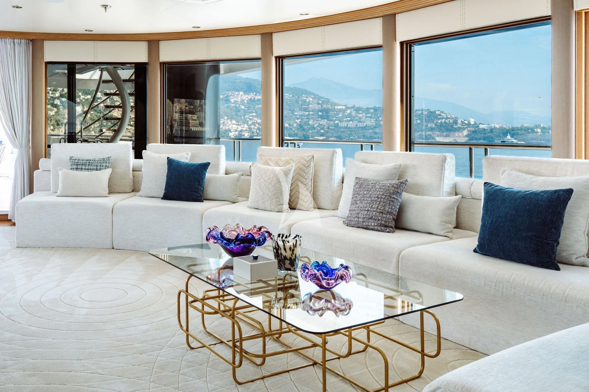 a white couch with a coffee table in front of a large window aboard SAMIRA Yacht for Sale