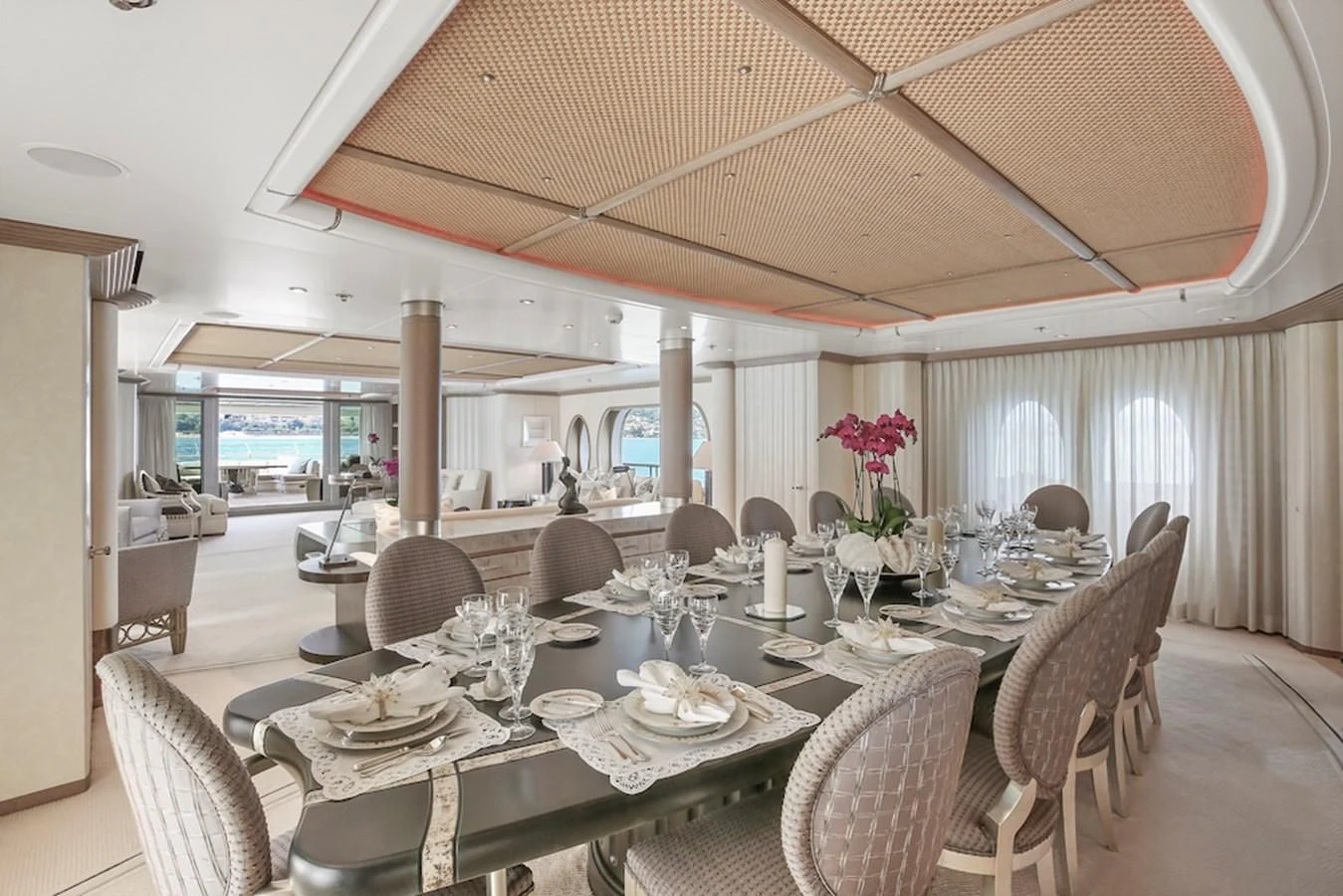 a large dining table with chairs and a large umbrella aboard SAMIRA Yacht for Sale