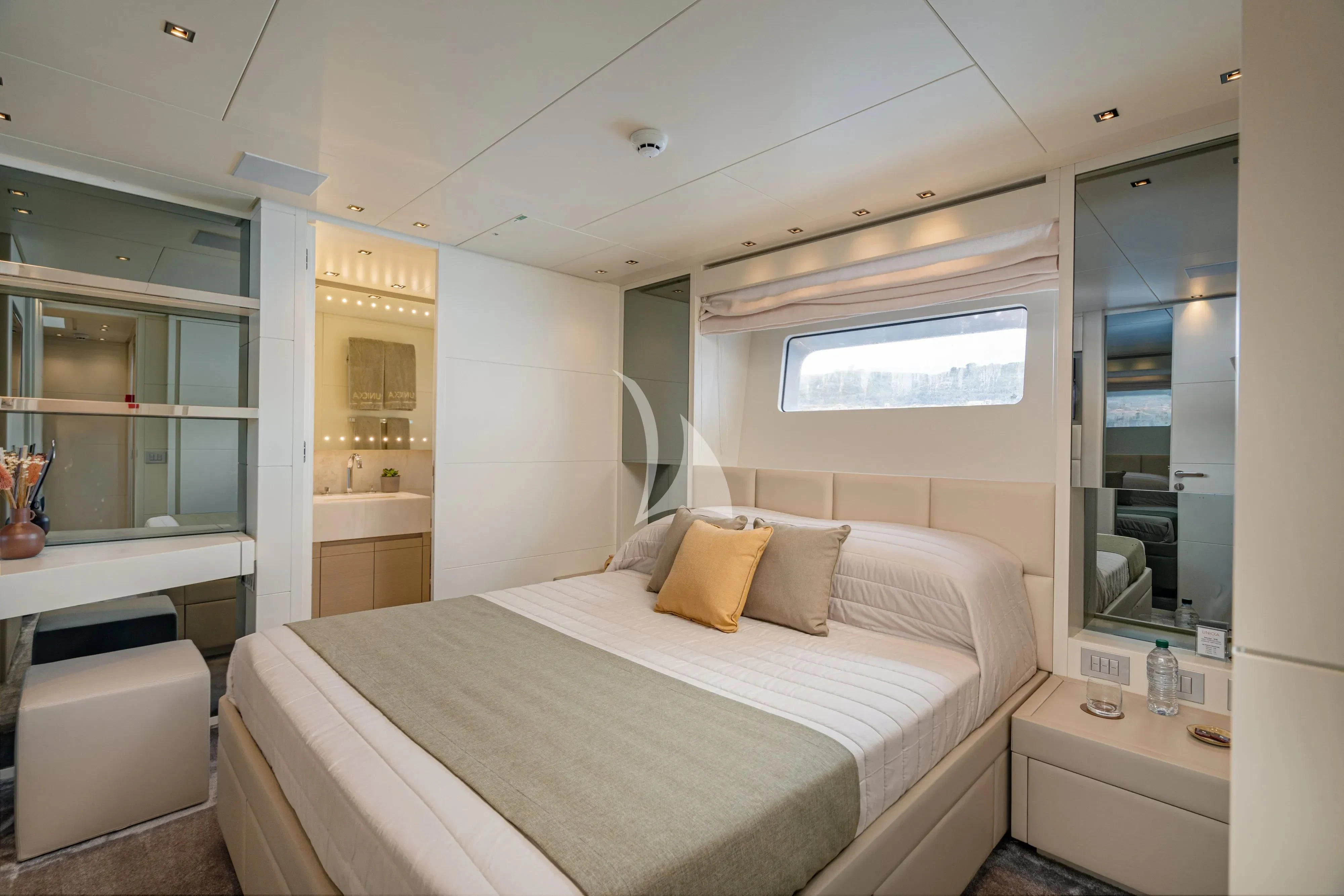 a bedroom with a bed and a mirror aboard UNICKA Yacht for Sale