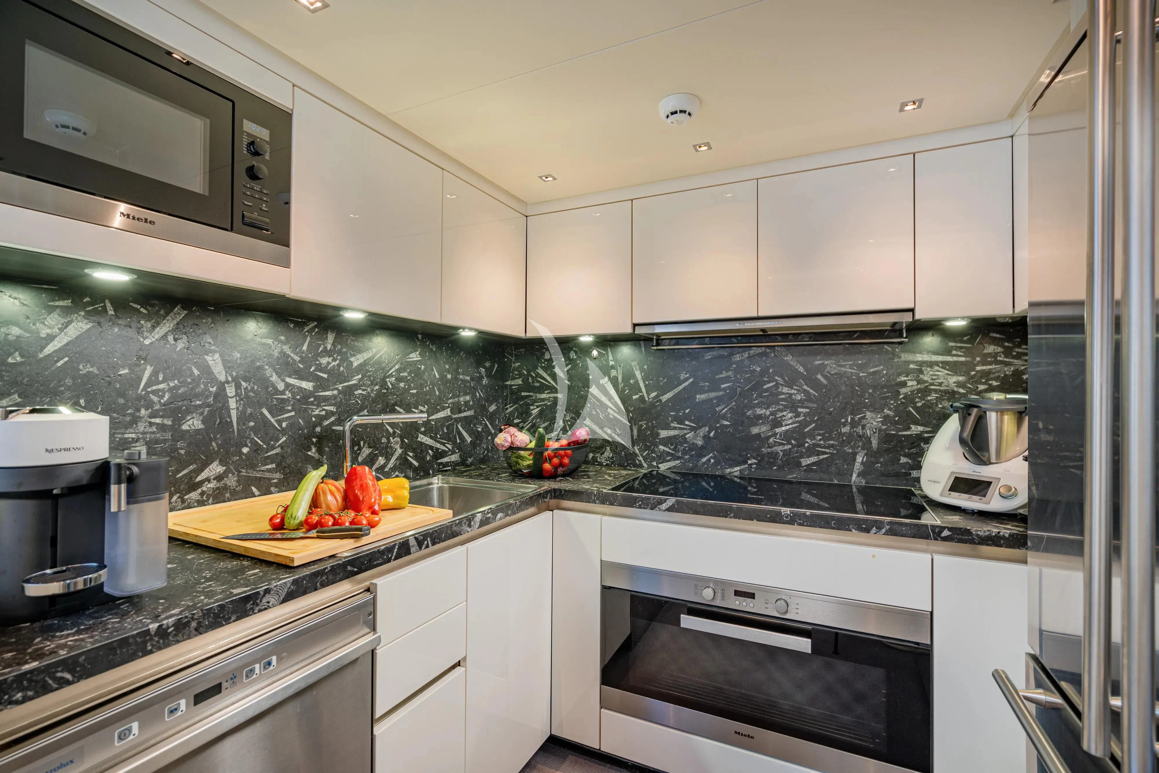 a kitchen with white cabinets aboard UNICKA Yacht for Sale