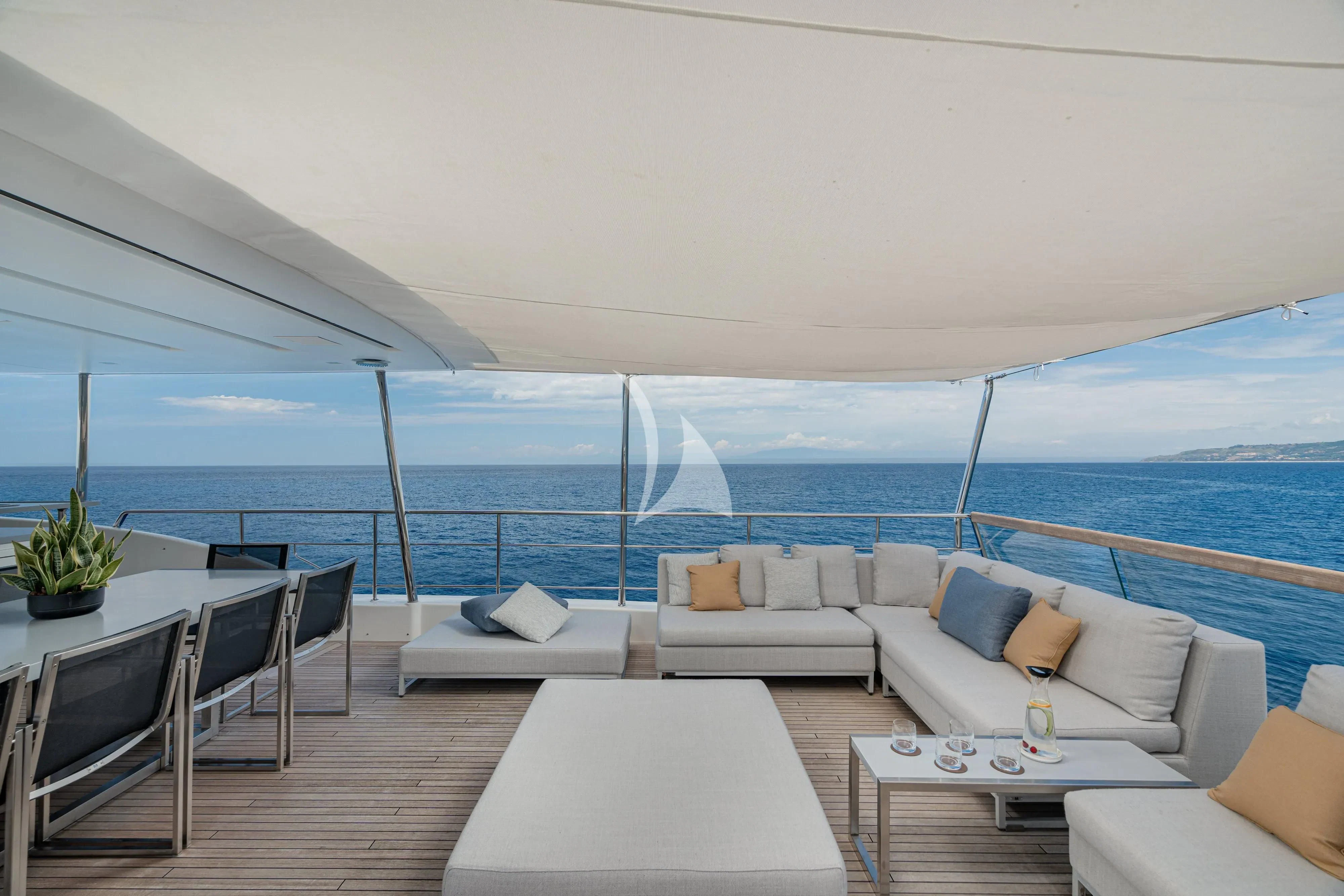 a room with a couch and a table and a large body of water aboard UNICKA Yacht for Sale