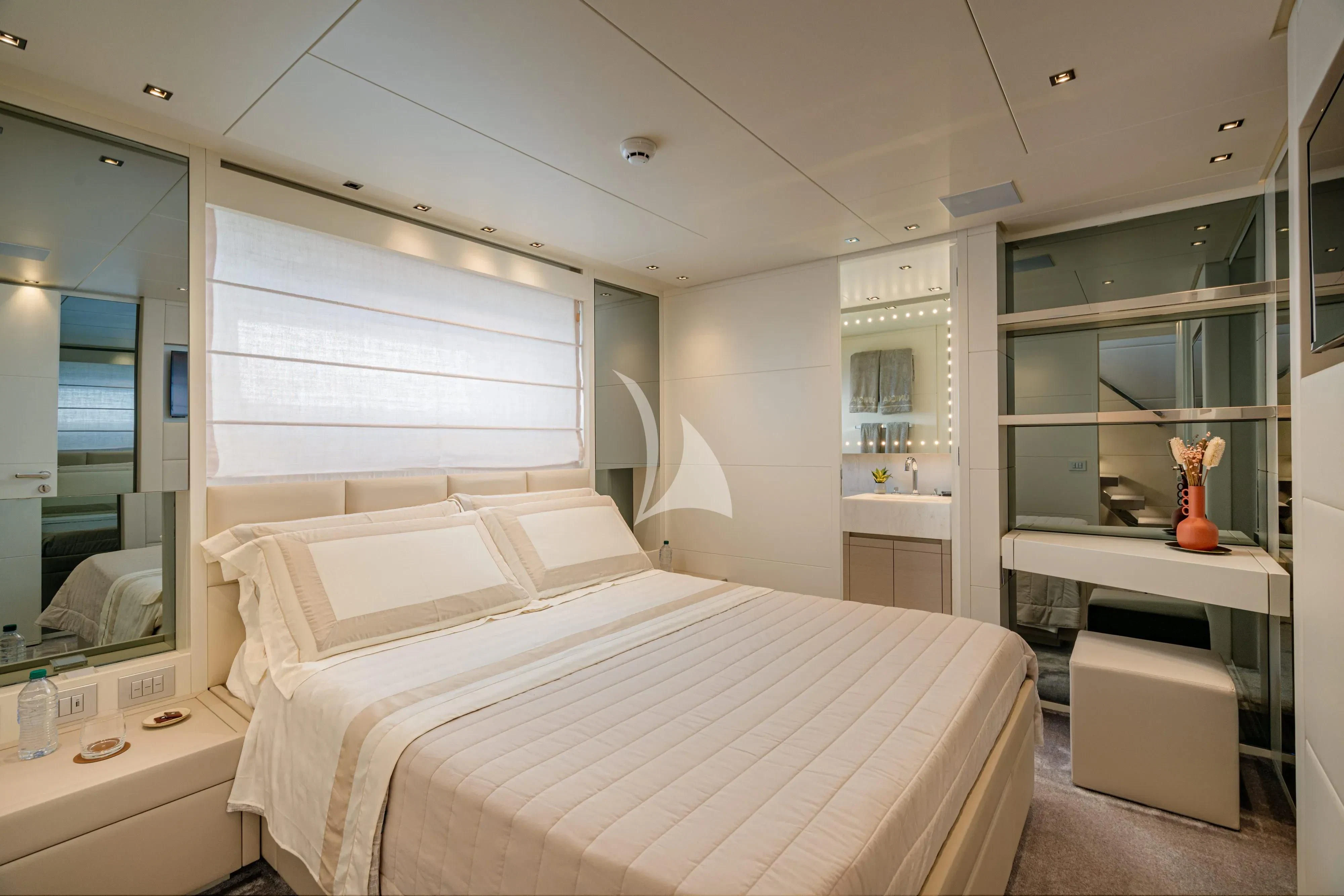 a bedroom with a bed and a mirror aboard UNICKA Yacht for Sale