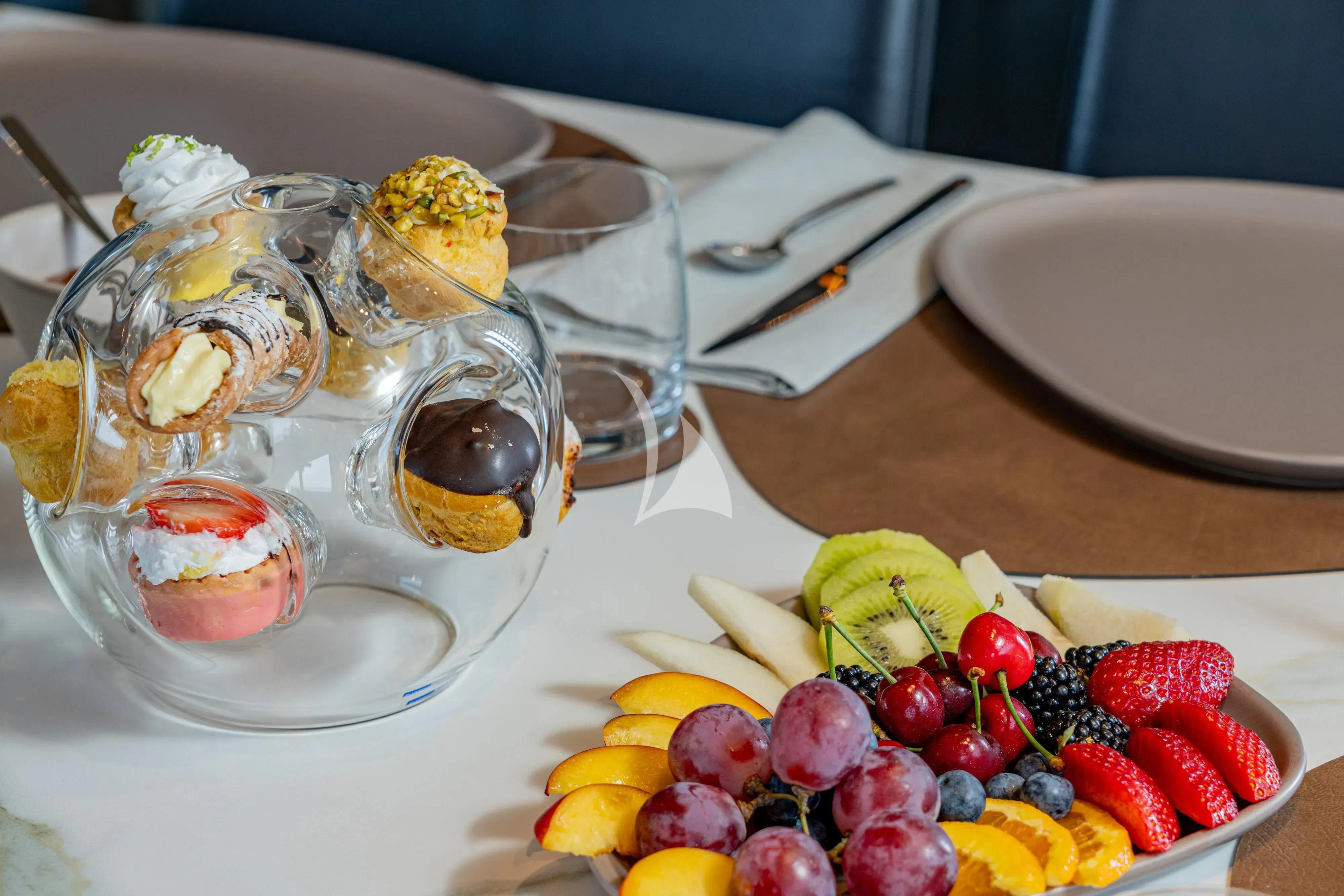 a table with food and drinks on it aboard UNICKA Yacht for Sale