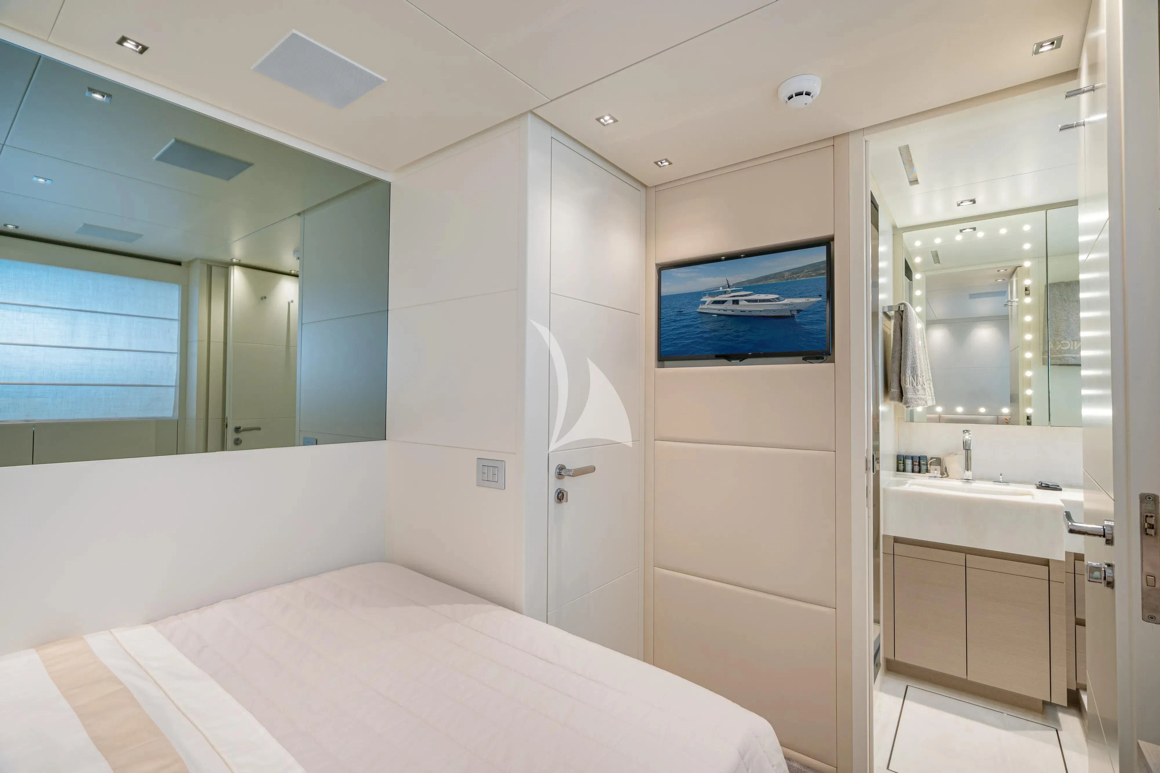 a bedroom with a large mirror aboard UNICKA Yacht for Sale