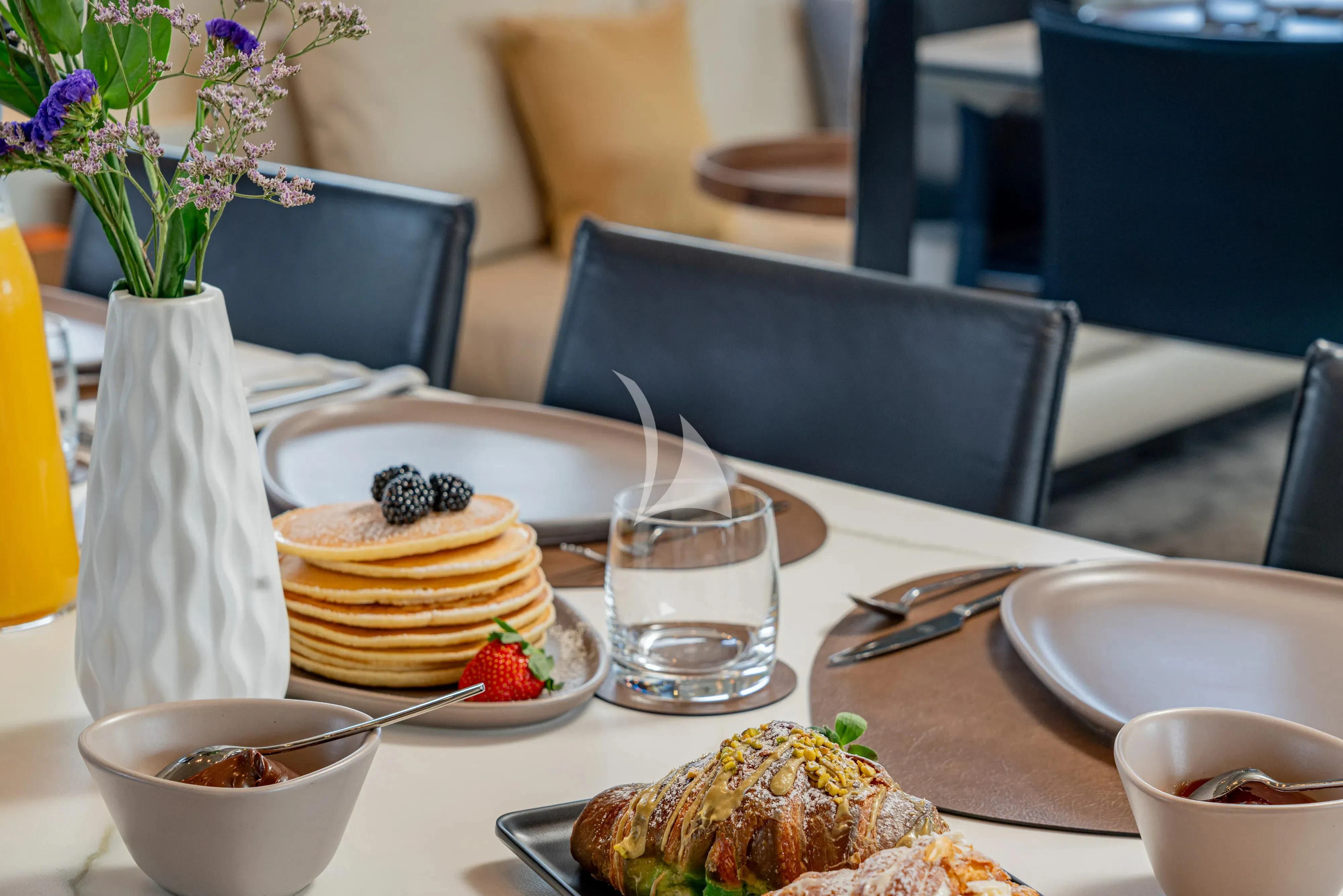 a table with food and drinks aboard UNICKA Yacht for Sale