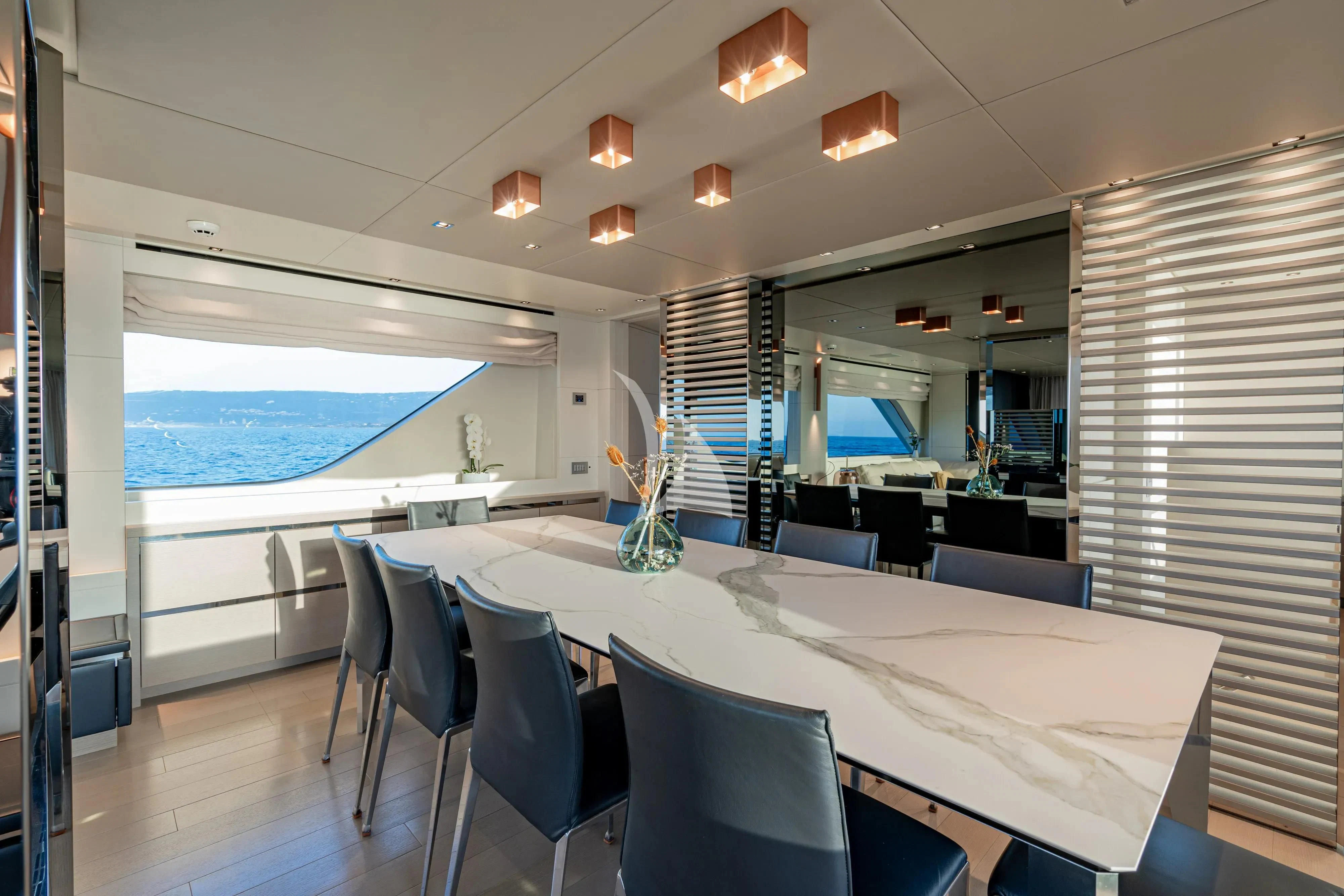 a room with a table and chairs aboard UNICKA Yacht for Sale
