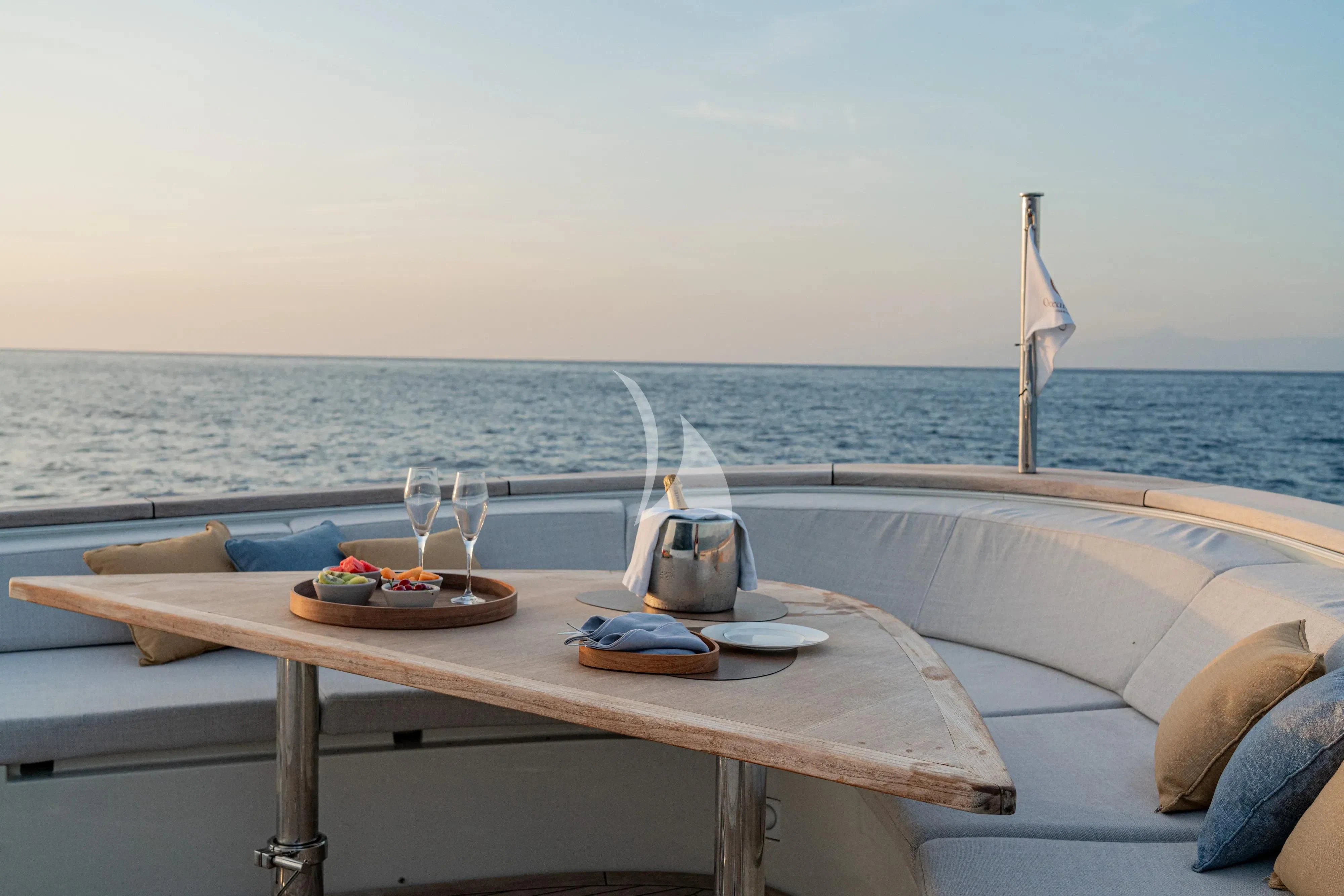 a table with a plate of food and glasses on it aboard UNICKA Yacht for Sale