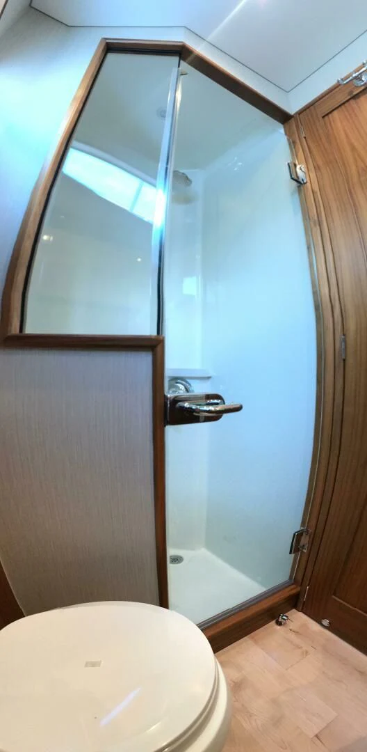 a bathroom with a toilet and a wooden door aboard PRIVATEER Yacht for Sale