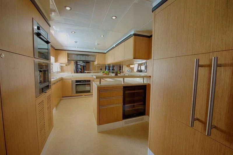 a kitchen with wooden cabinets aboard OCTOBER Yacht for Sale