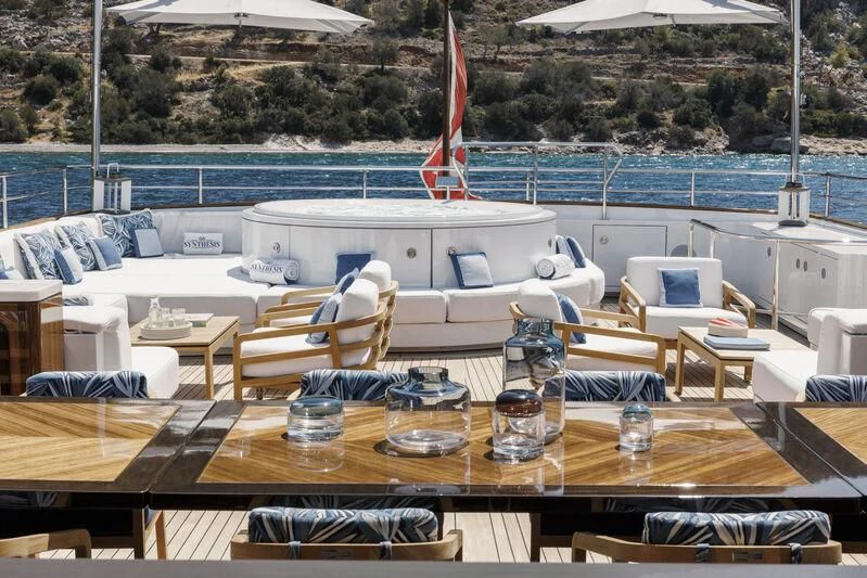 a table with glasses and a bottle on it aboard SYNTHESIS 66 Yacht for Sale