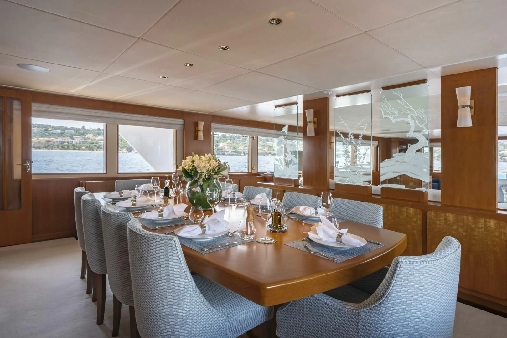 a dining table with chairs and a large window aboard SYNTHESIS 66 Yacht for Sale