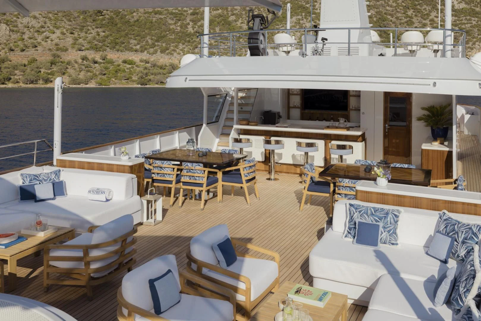 a room with tables chairs and a large white building with a white roof aboard SYNTHESIS 66 Yacht for Sale