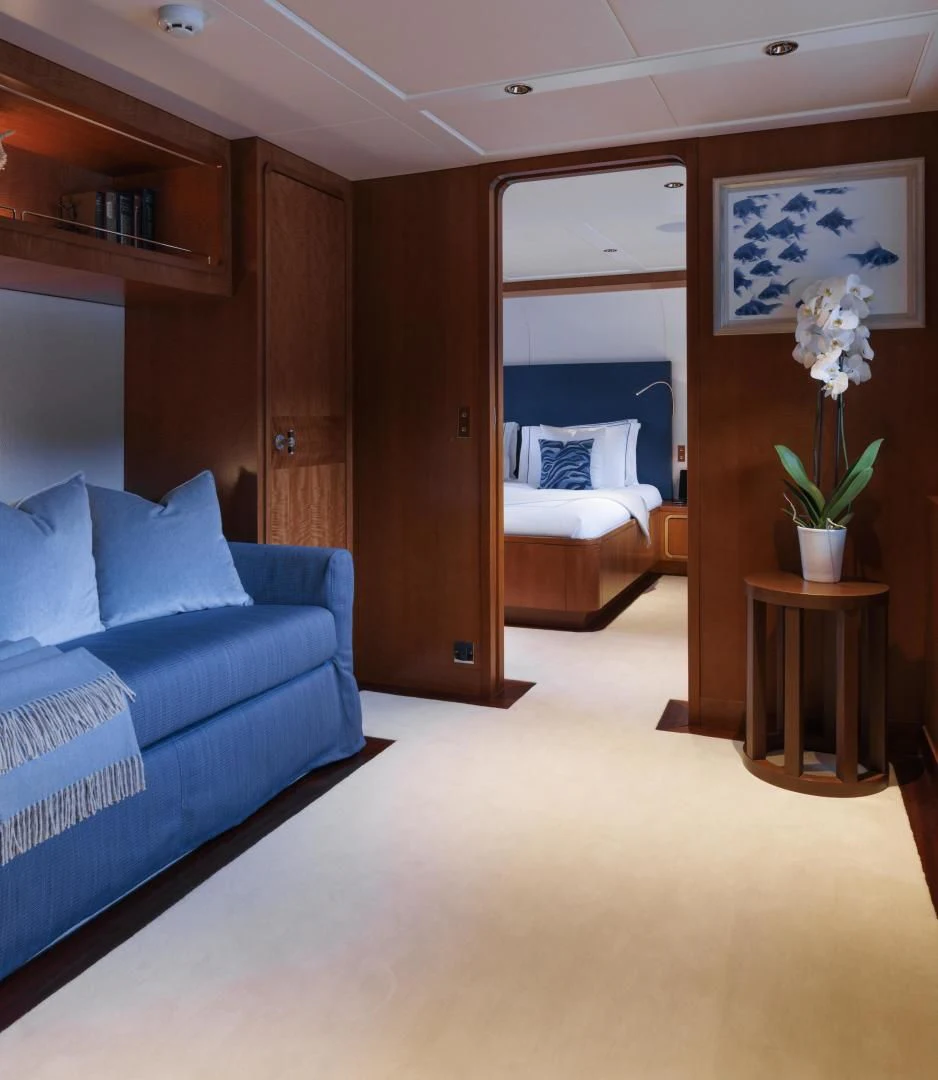a living room with a blue couch aboard SYNTHESIS 66 Yacht for Sale